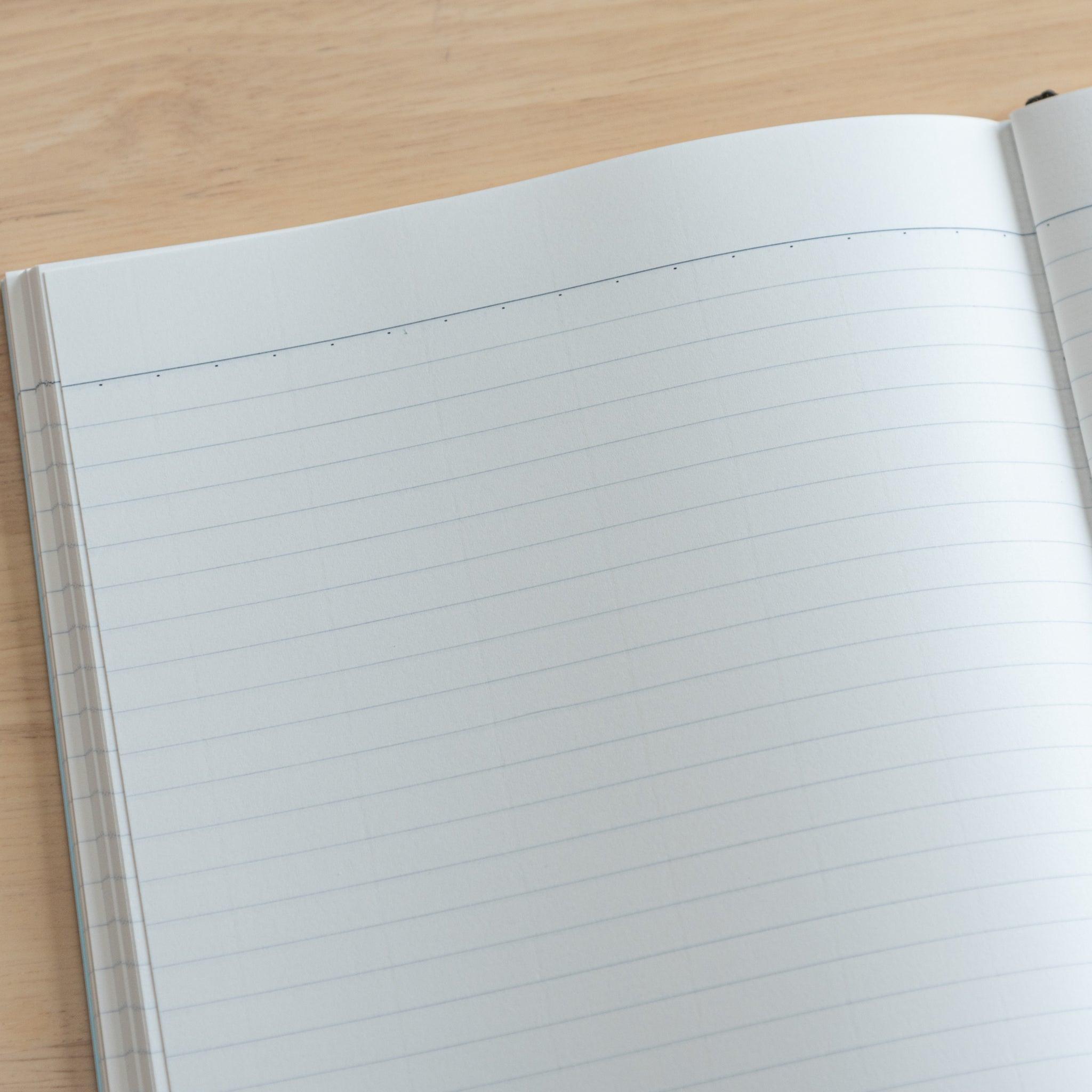 A fully opened Japanese notebook displaying two lined pages with subtle blue margins, crafted with high-quality paper and elegant Japanese stationery design.