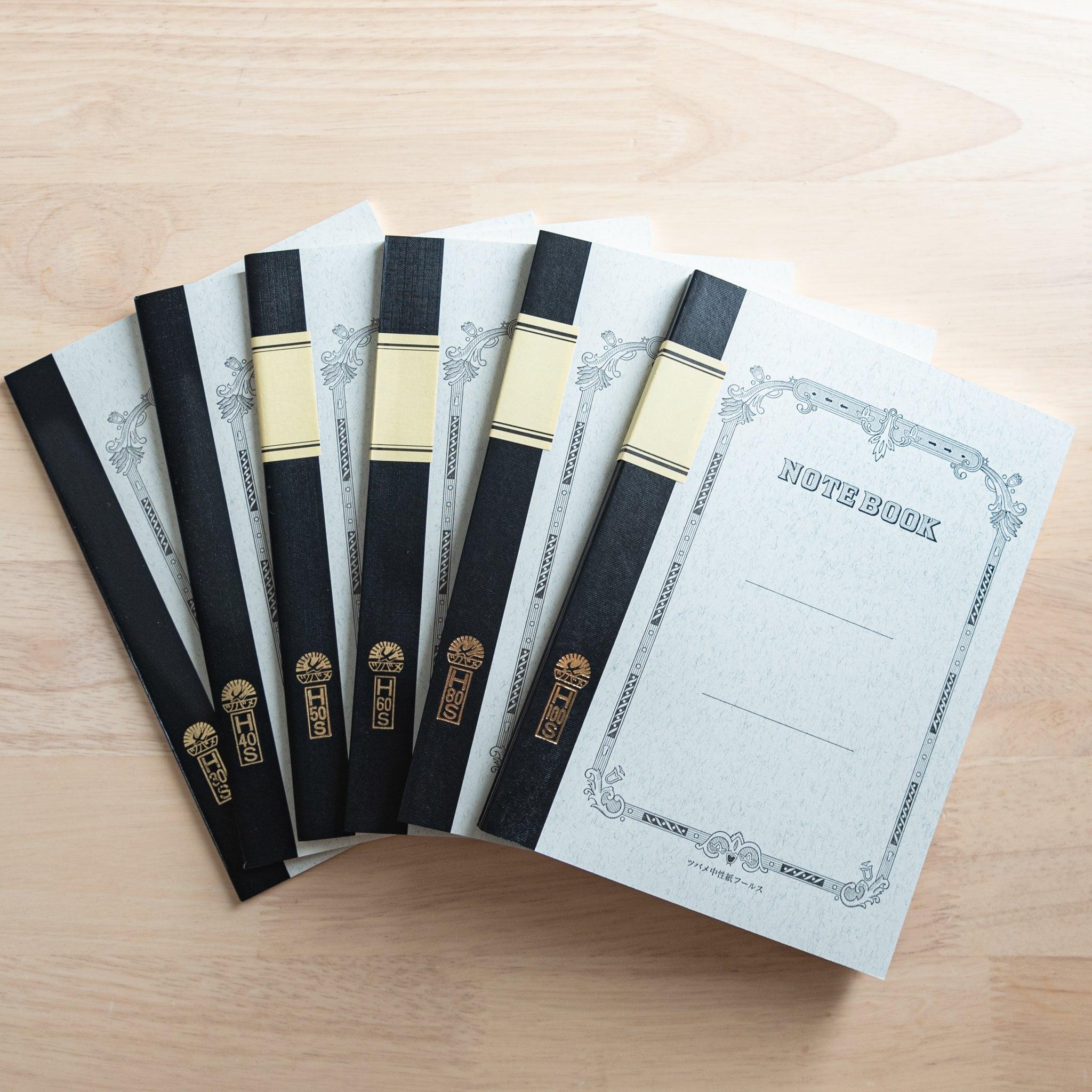 A set of Tsubame Japanese notebooks with decorative covers, black spine bindings, and gold lettering, showcasing high-quality Japanese stationery.