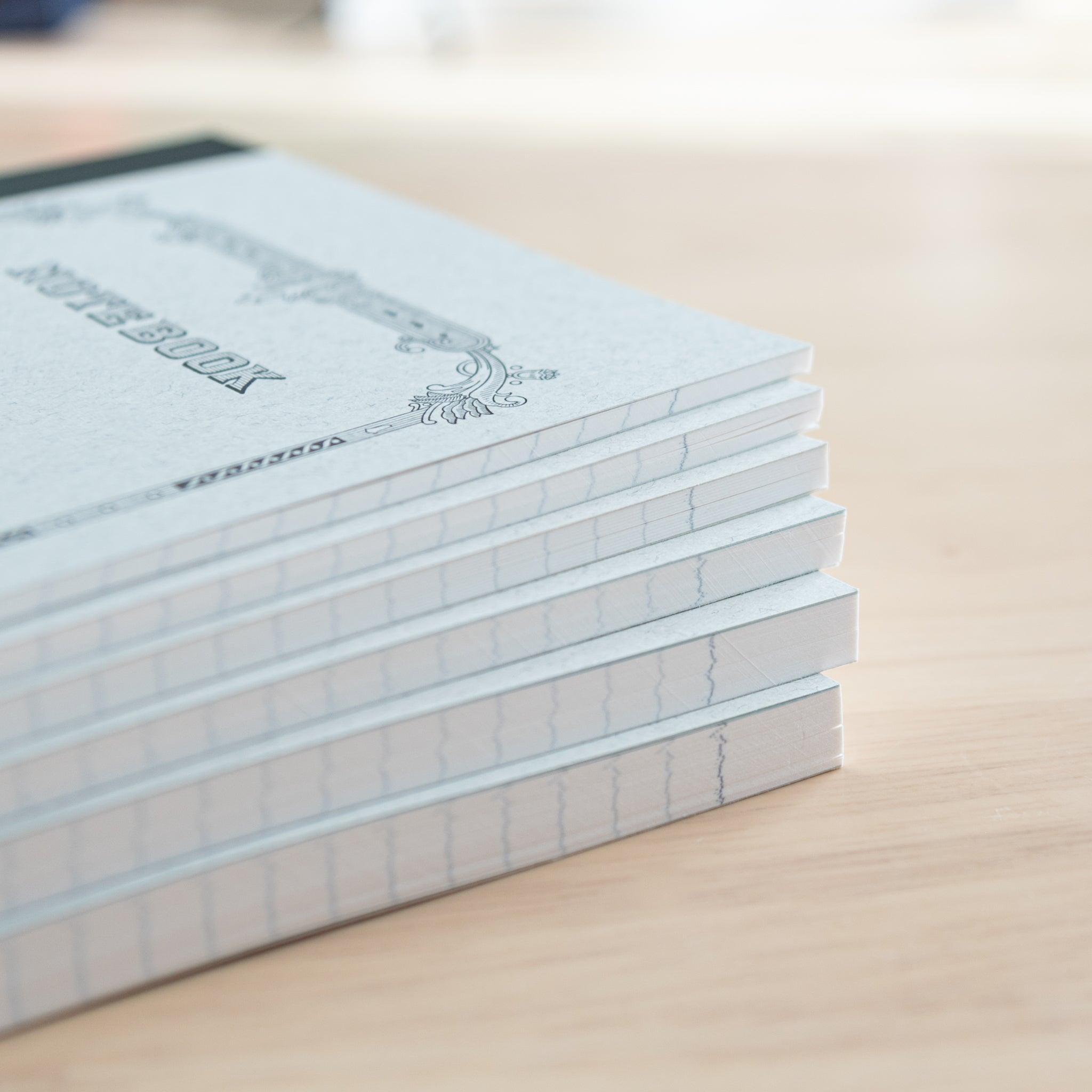 A close-up of stacked Tsubame Japanese notebooks with stitched bindings and high-quality paper edges, emphasizing fine craftsmanship in Japanese stationery.