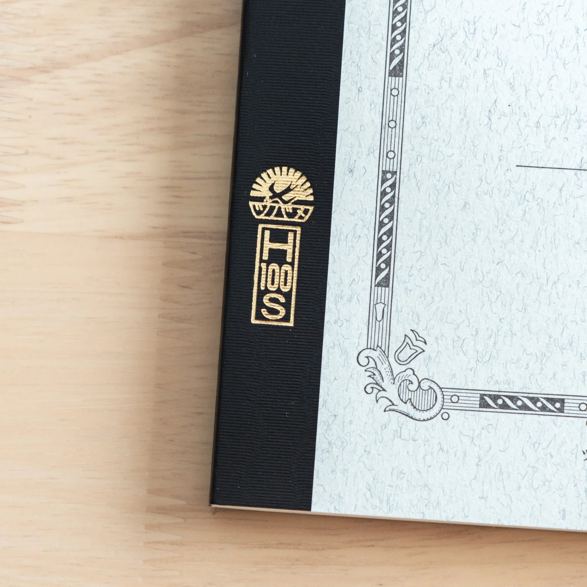 Spine binding detail showing textured black woven fabric and hand-stamped Japanese character markings