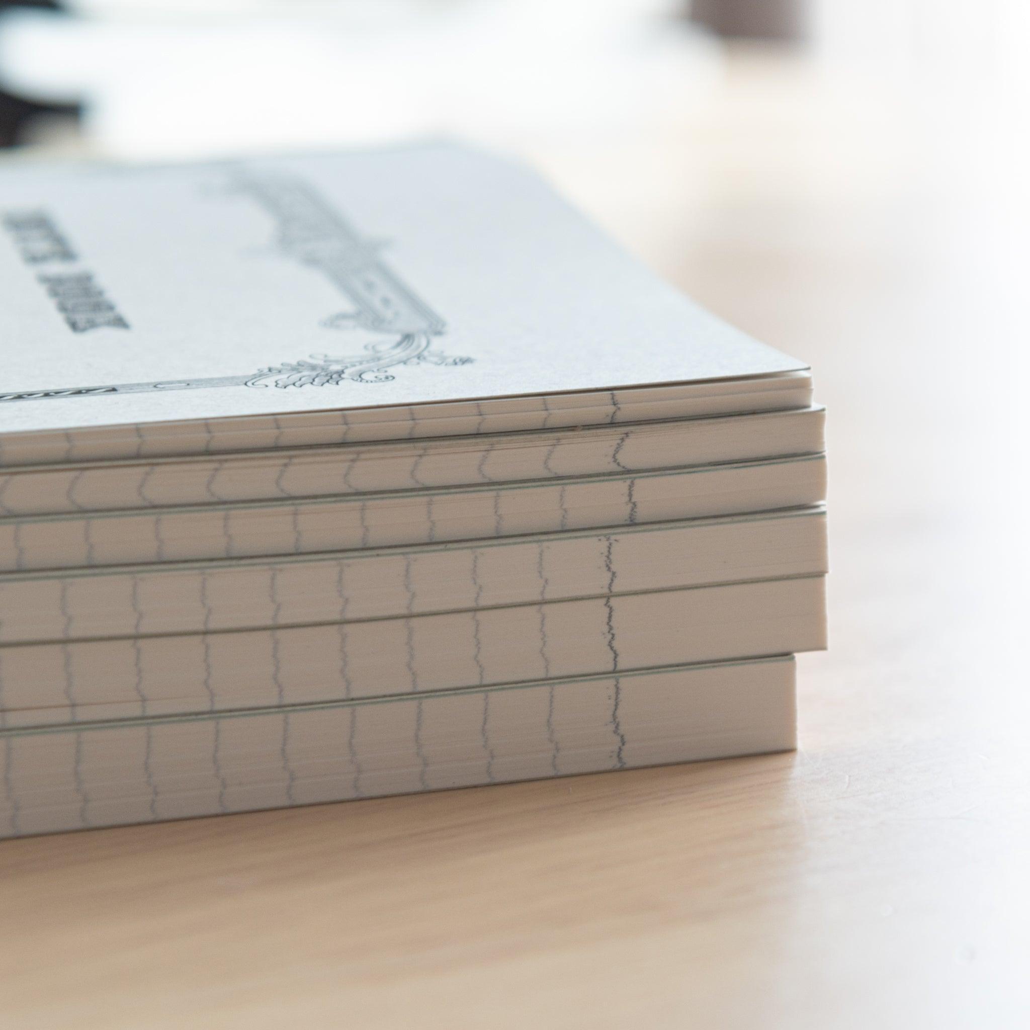 A close-up of stacked Tsubame Japanese notebooks with stitched bindings and high-quality paper edges, emphasizing fine craftsmanship in Japanese stationery.