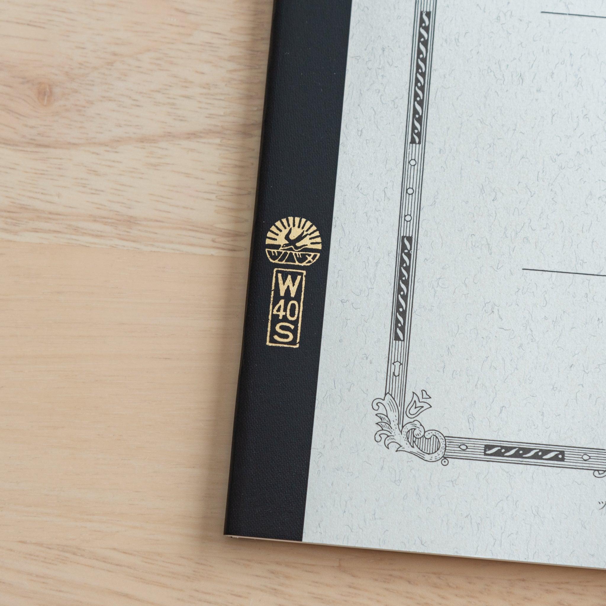 A close-up of the Tsubame Japanese notebook’s gold-stamped spine label, featuring the brand’s logo and model number, emphasizing fine Japanese stationery details.