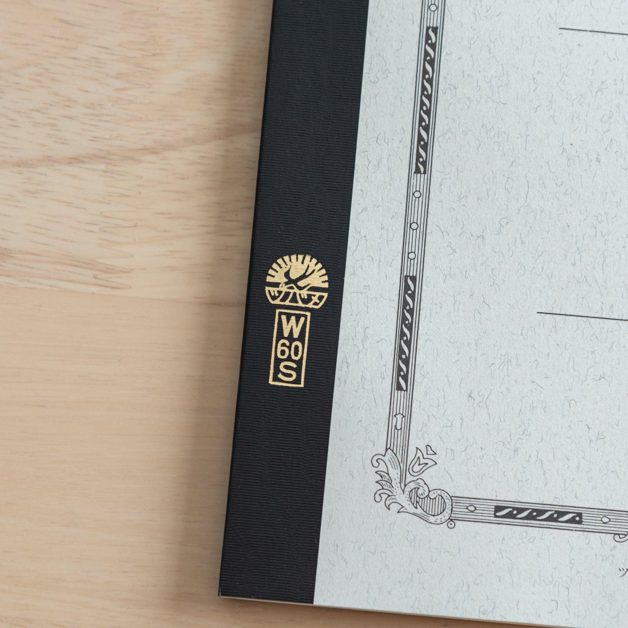 A close-up of the Tsubame Japanese notebook’s gold-stamped spine label, featuring the brand’s logo and model number, emphasizing fine Japanese stationery details.