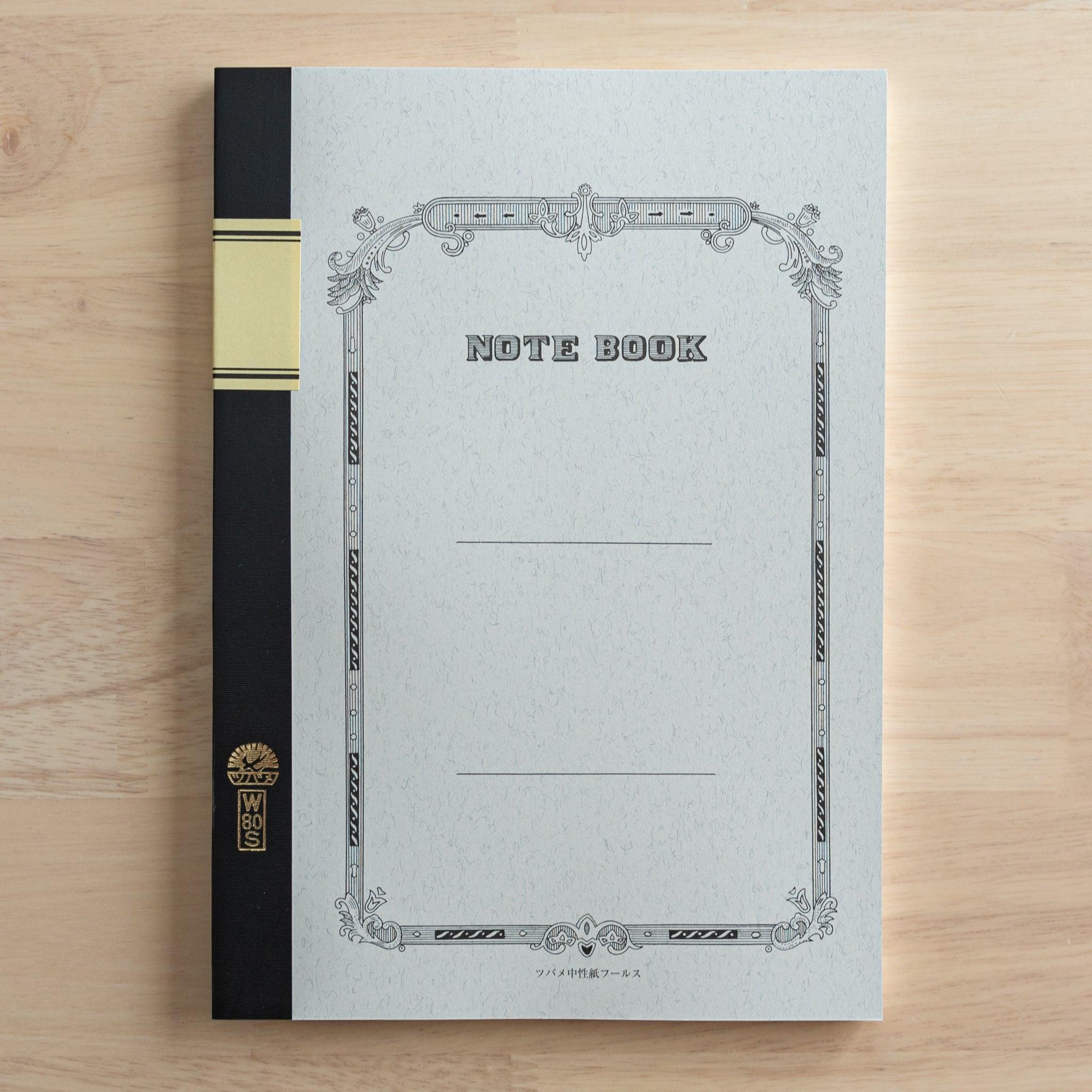 A Tsubame Japanese notebook with a decorative cover, black spine, and a gold label, showcasing the elegant and classic design of high-quality Japanese stationery.