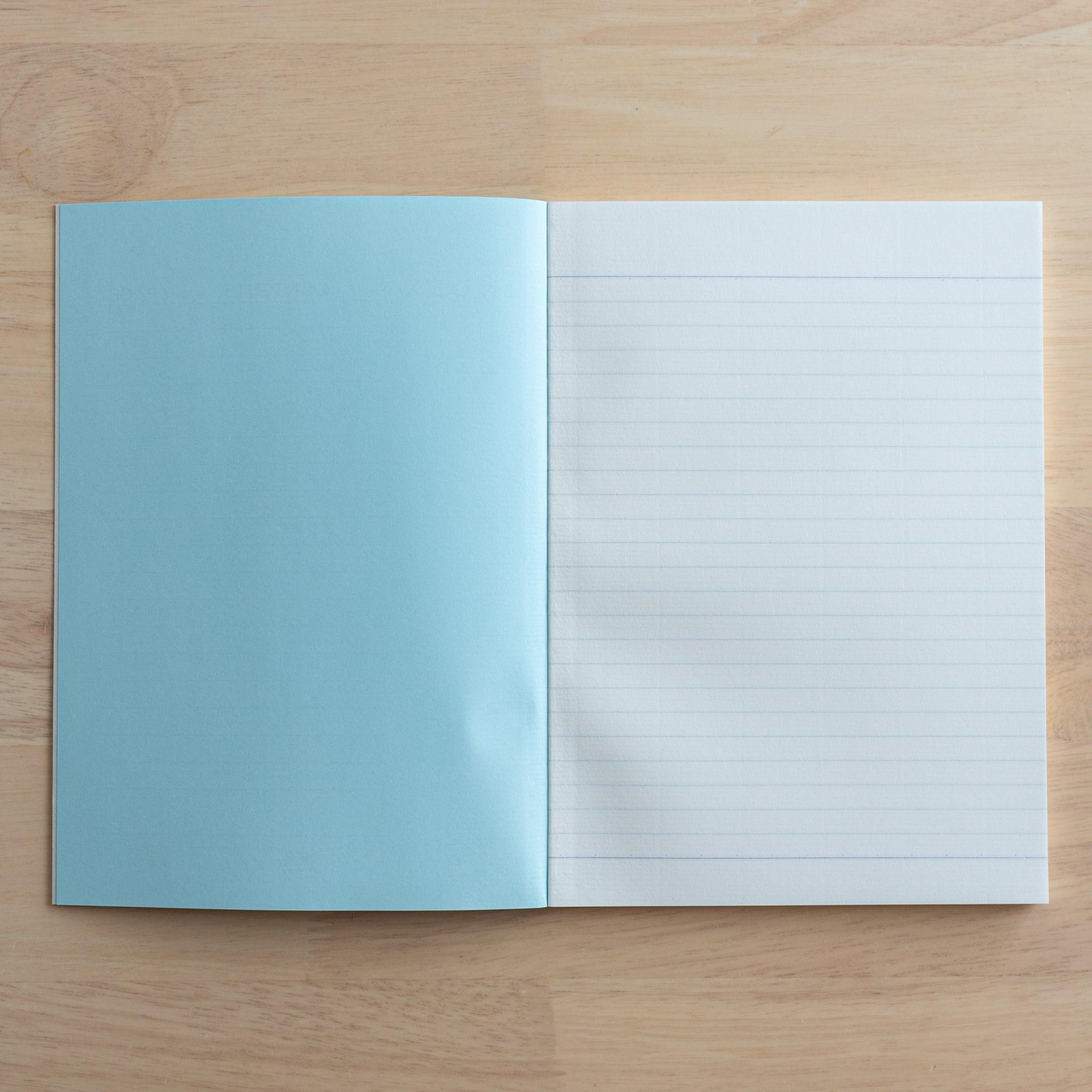 An open Tsubame Japanese notebook showing a blue inner cover on the left and a lined page on the right, crafted with high-quality paper and classic Japanese stationery design.