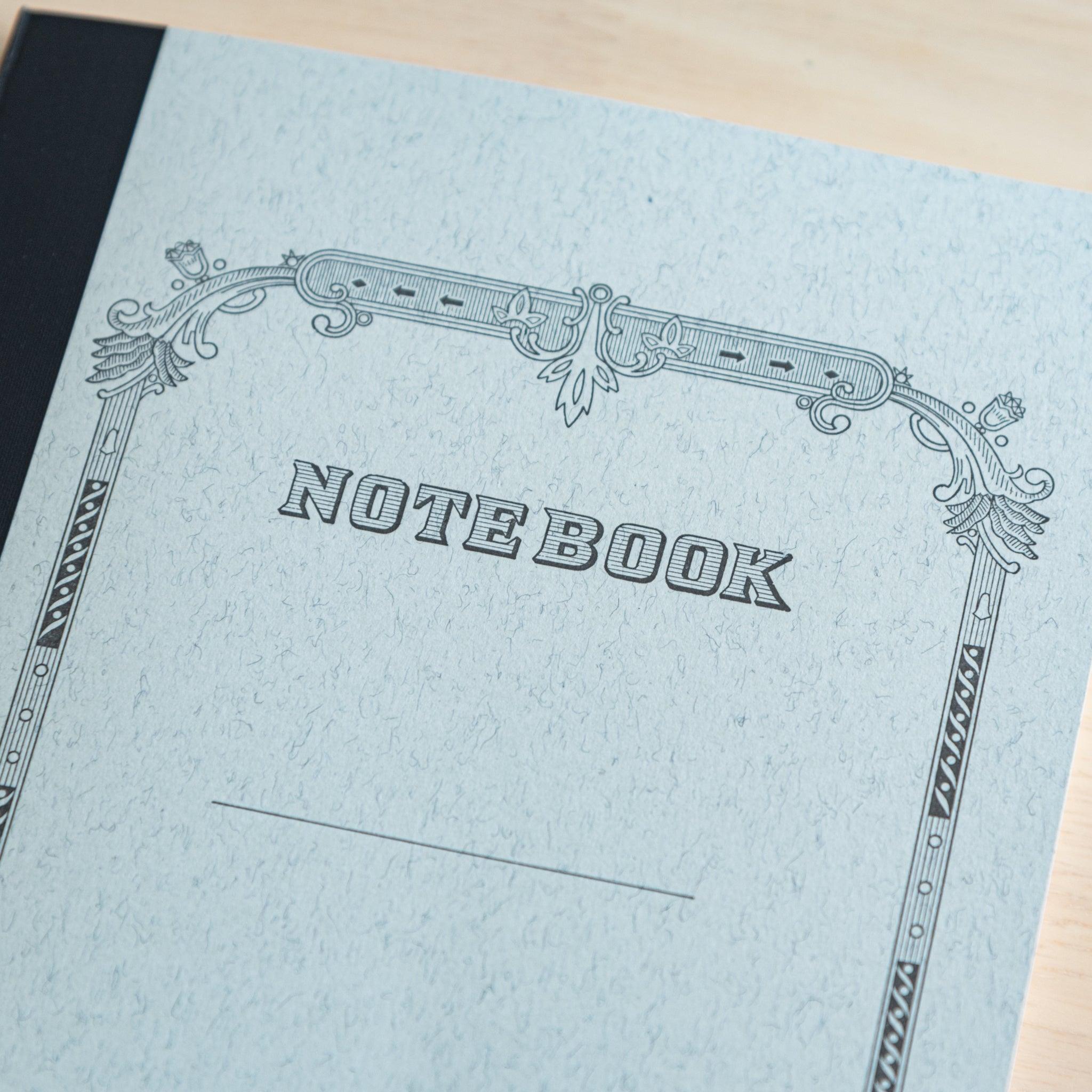 A close-up of a Tsubame Japanese notebook’s cover, featuring an ornate black and white frame design with "NOTEBOOK" in bold, showcasing classic Japanese stationery.