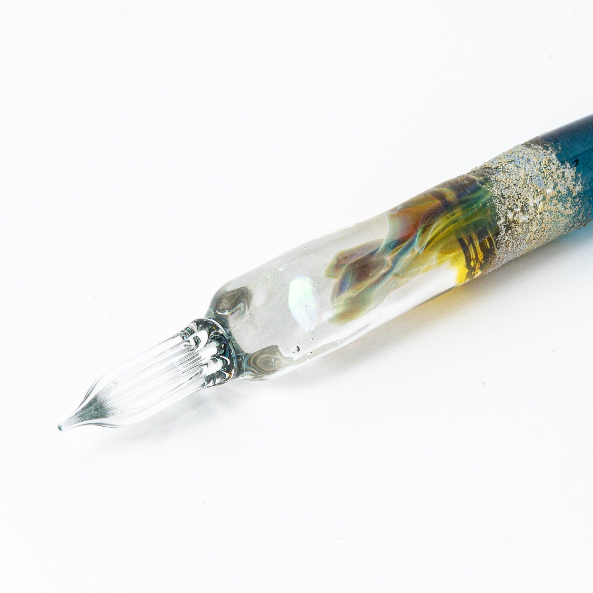 Practical demonstration of deep blue glass dip pen being used for writing and decorative lettering practice shine