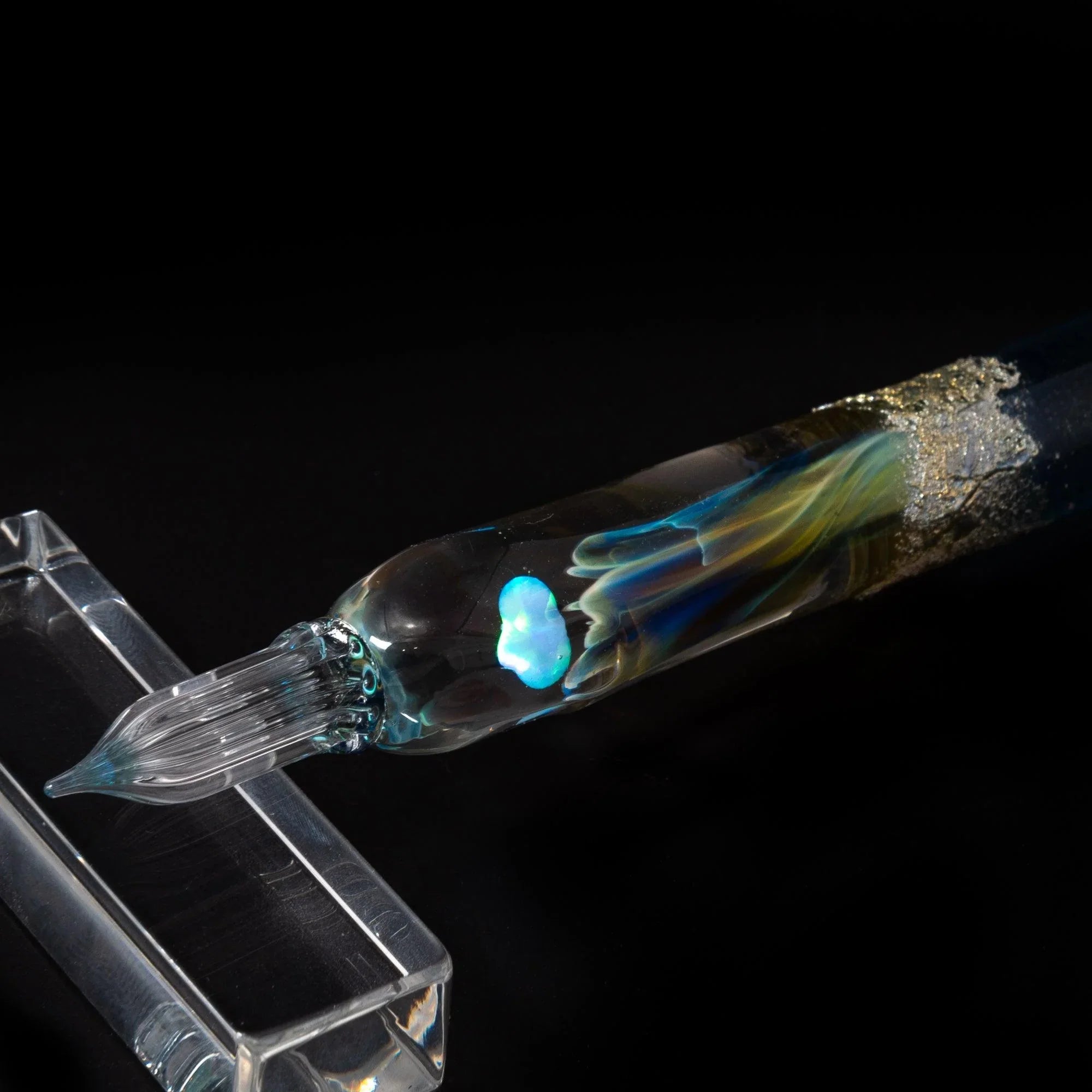 Light blue glass dip pen photographed for calligraphy and lettering work with twisted nib and smooth barrel shine
