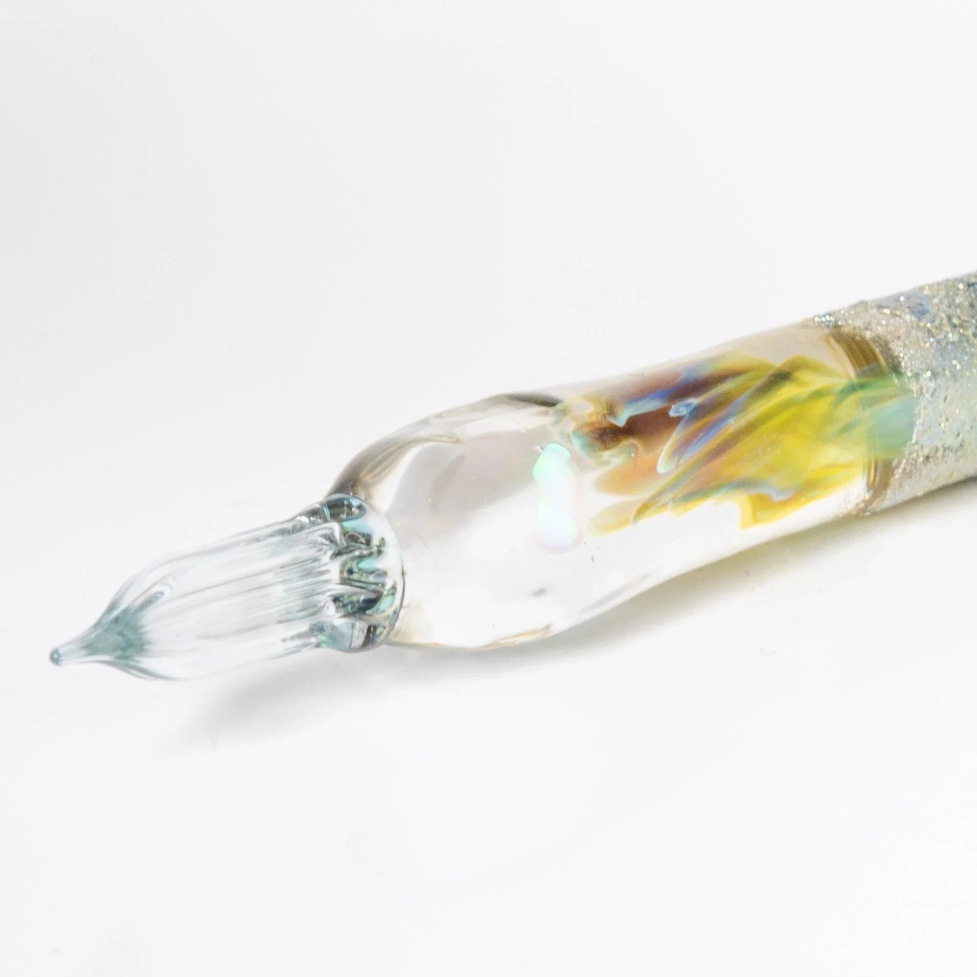 Light blue glass dip pen in profile view showing elongated transparent barrel with hand-made nib detail shine