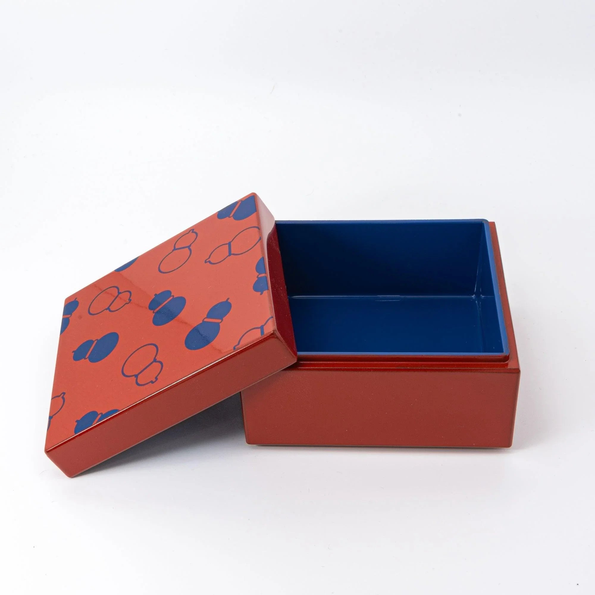 Kohako gourd lacquer trinket box at three-quarter angle showing coral urushi with filled and outlined gourd motifs