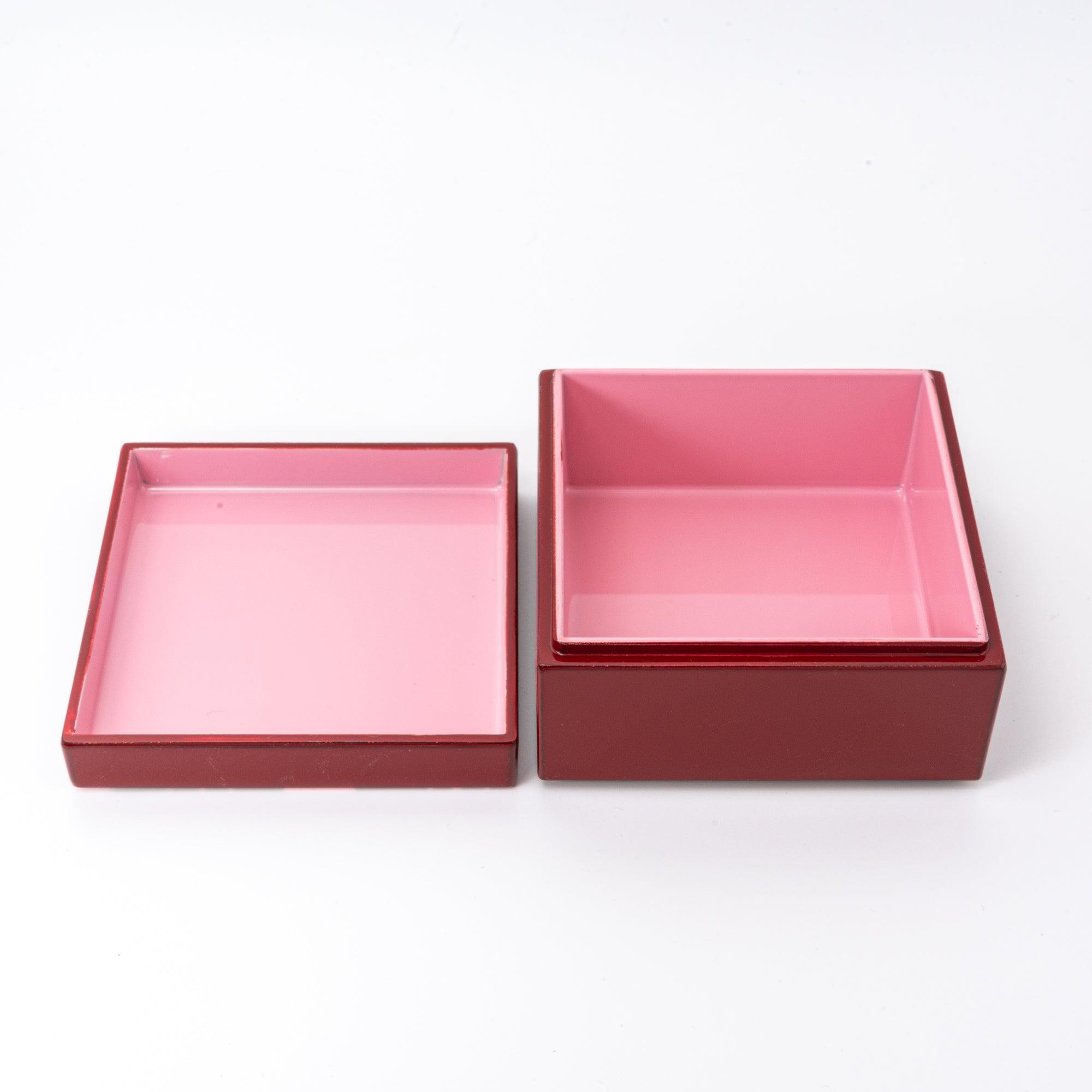 Red Japanese lacquer stationery box with pink plum blossom patterns, separated into lid and base, revealing a light pink interior against a white background.