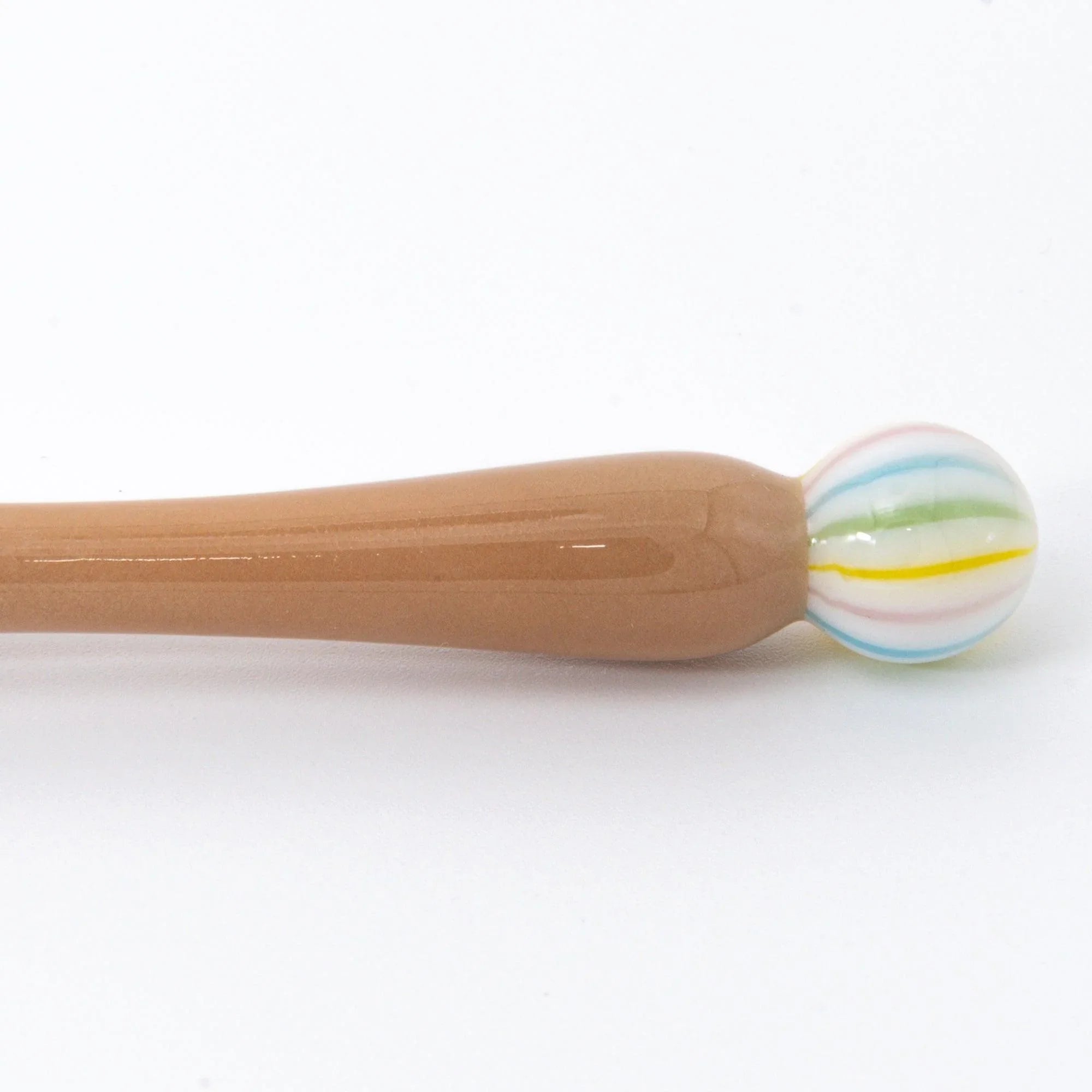 Wagashi Monaka wooden handle in foreground with rainbow striped glass bulb positioned right with handle detail and