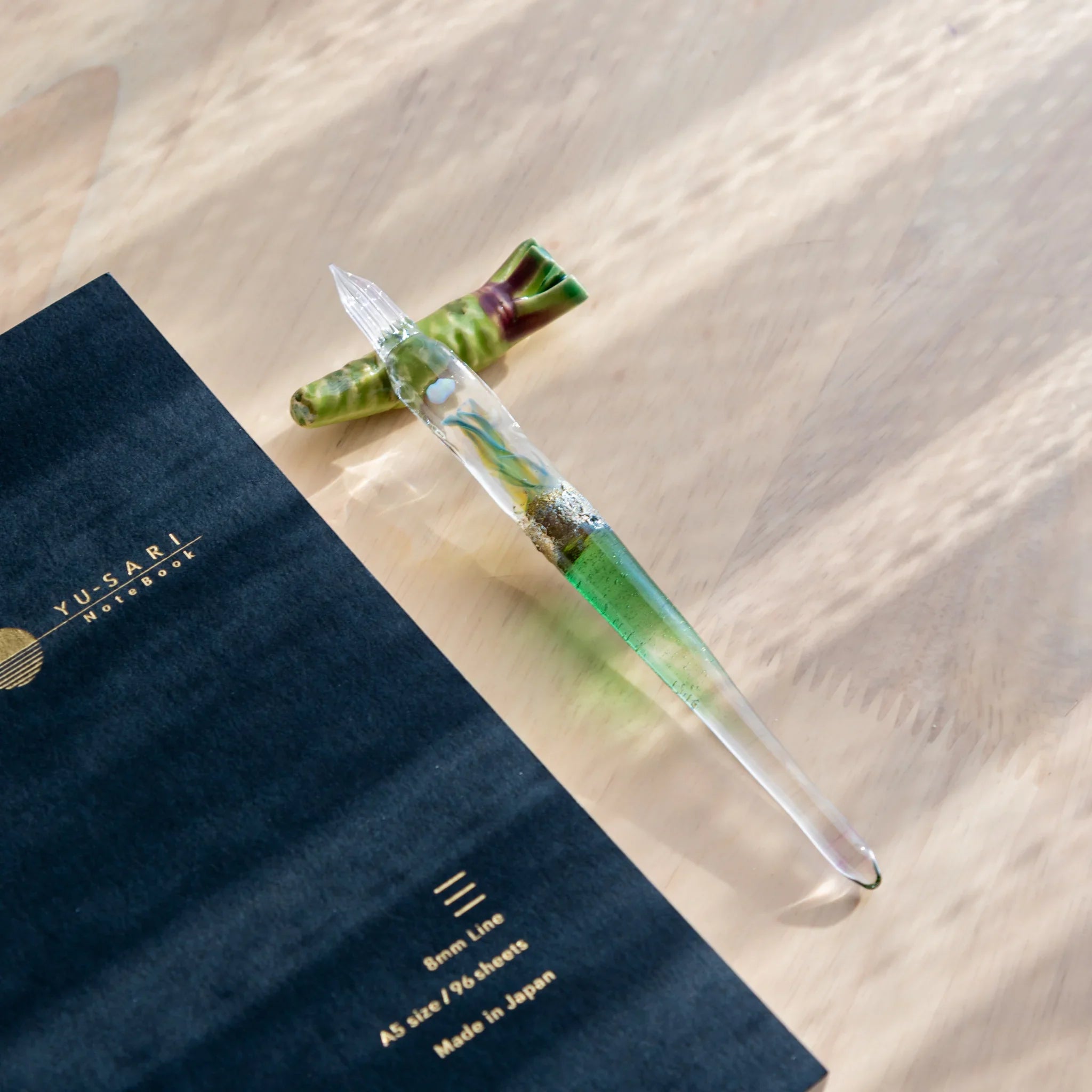 Vibrant green wasabi handcrafted pen rest displaying characteristic bumpy texture and detailed surface on neutral surface