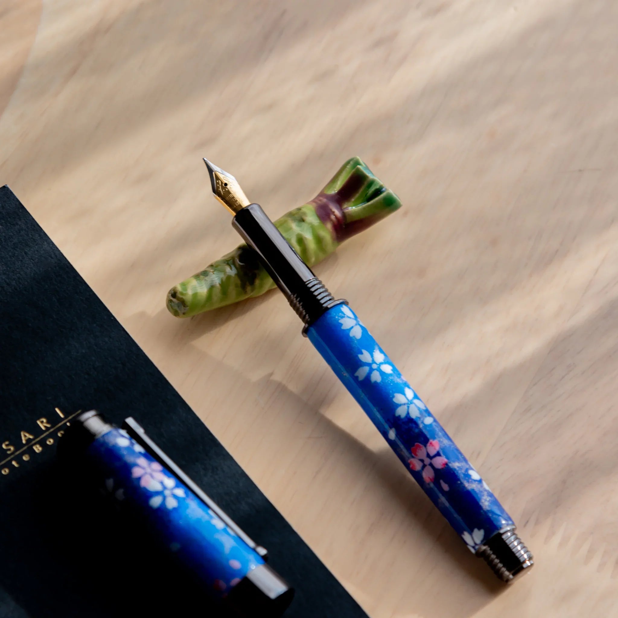 Bright green wasabi-shaped Japanese handcrafted pen rest featuring authentic Japanese design overall on neutral surface