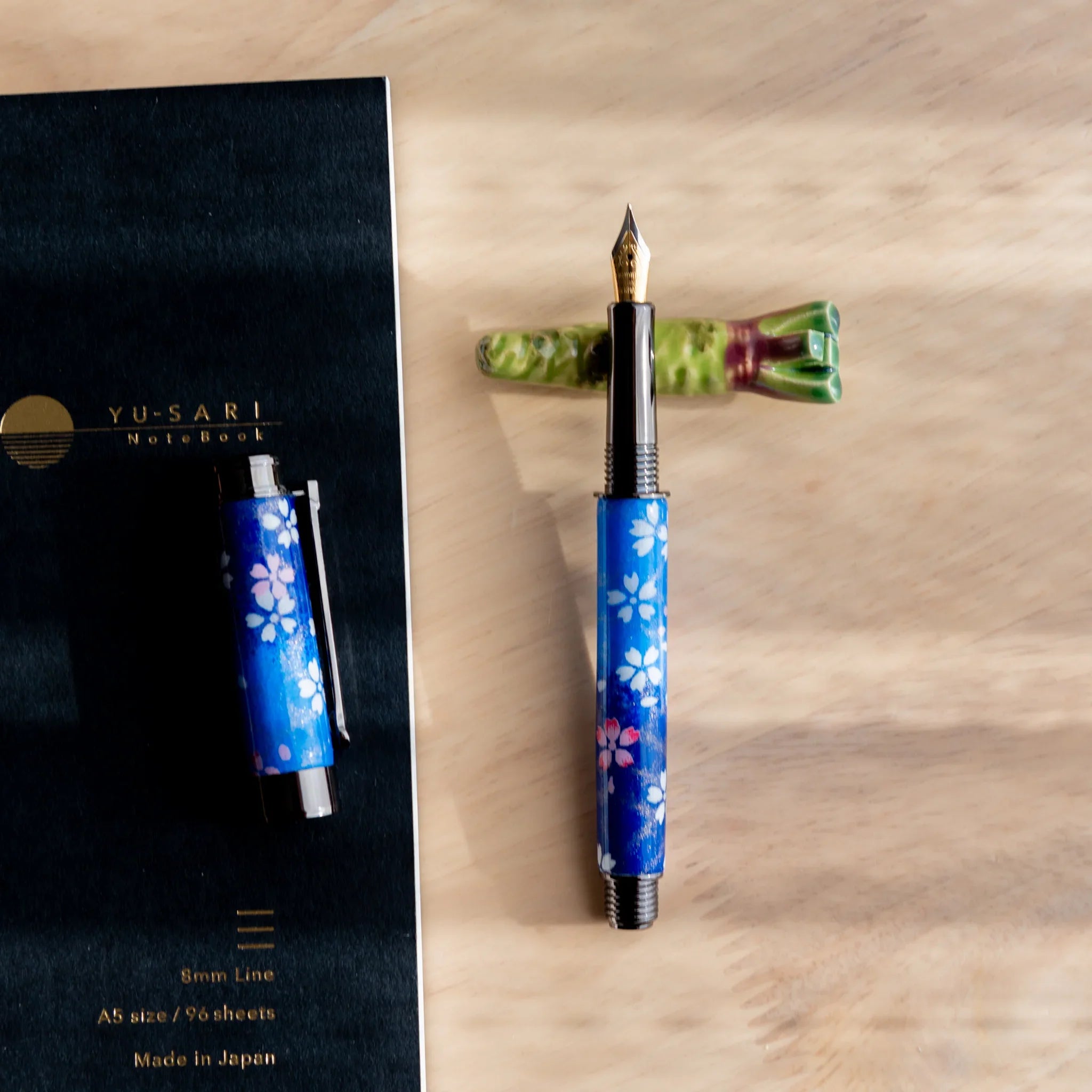 Neon green wasabi ceramic handcrafted pen rest with characteristic bumpy exterior surface and groove close shot