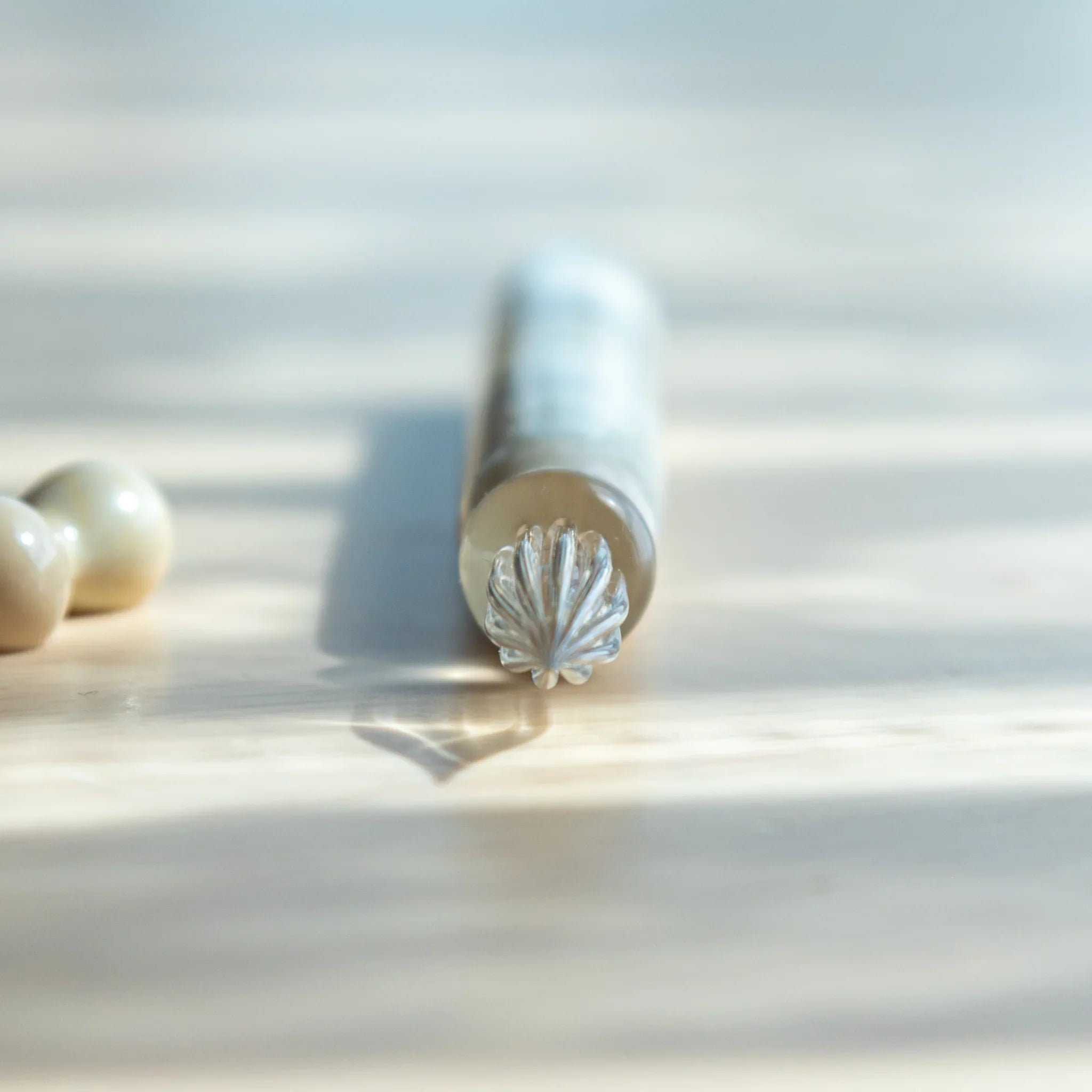 White glass dip pen featuring hemp leaves asa no ha pattern band displayed beside dark blue notebook