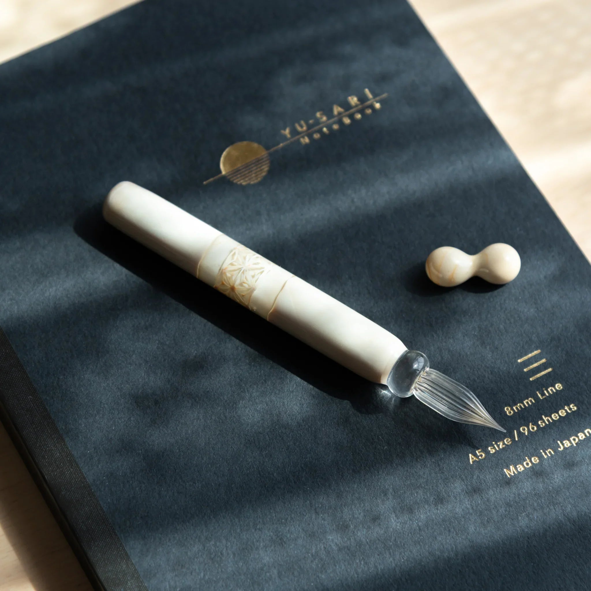 Close-up of asa no ha hemp pattern band on white glass dip pen showing detailed traditional leaf design