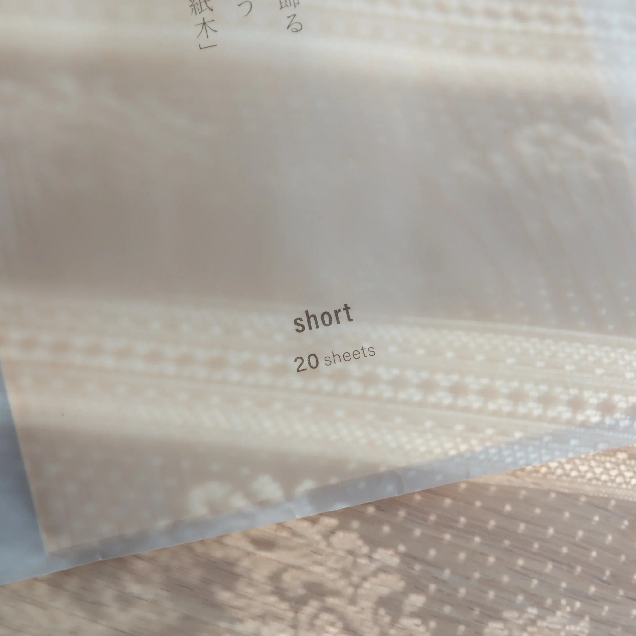 Close-up of Shiki package bottom showing short and 20 sheets labels with Japanese text and wood grain texture visible