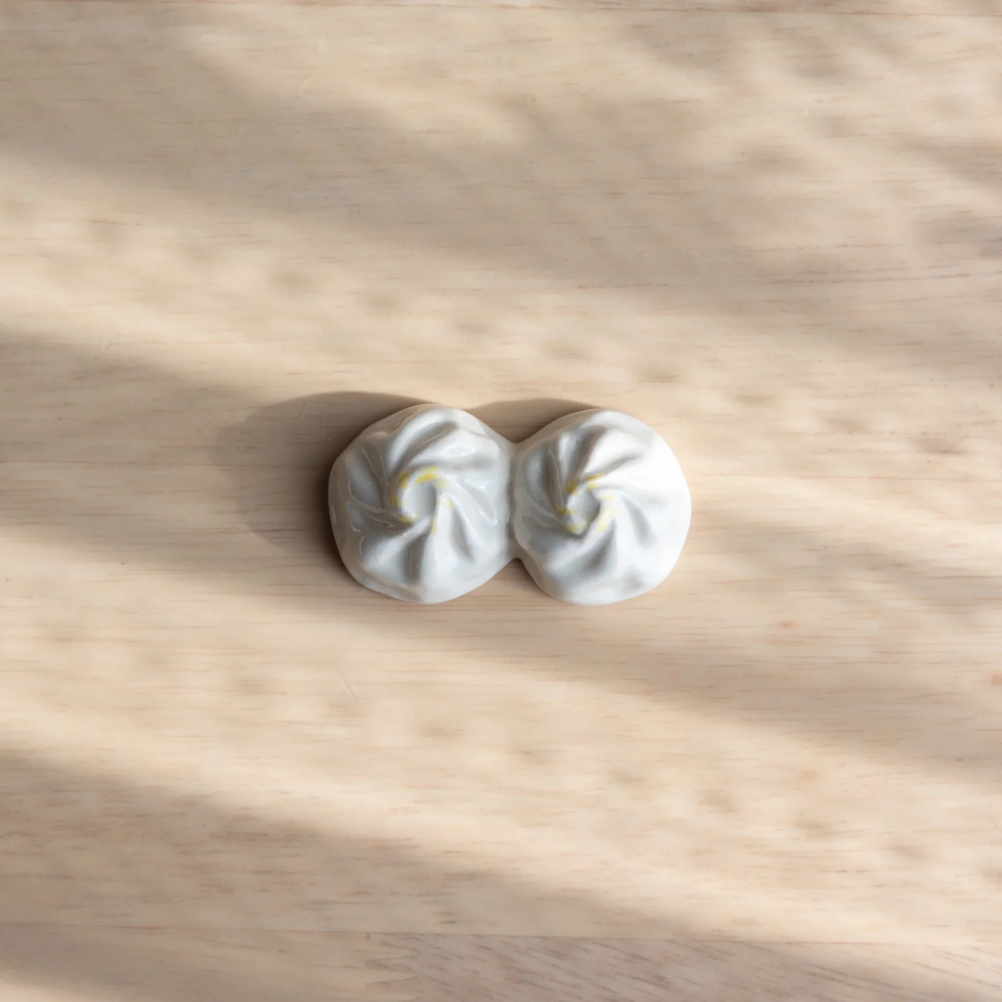 White xiaolongbao dumpling-shaped ceramic pen rest handcrafted in Japan with traditional pleated detail close shot
