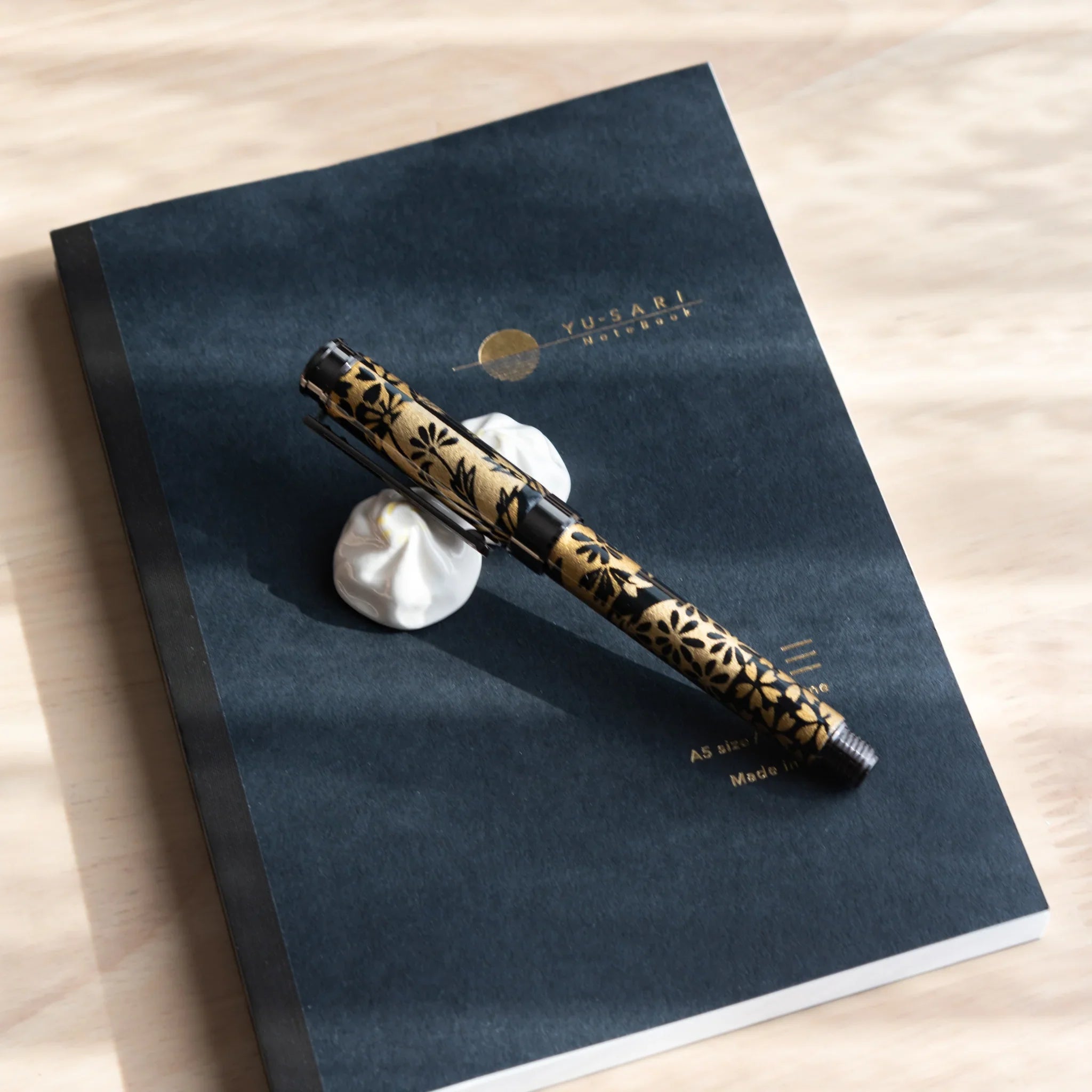 Xiaolongbao soup dumpling ceramic pen rest photographed from angled side view with Japanese handcraft close shot