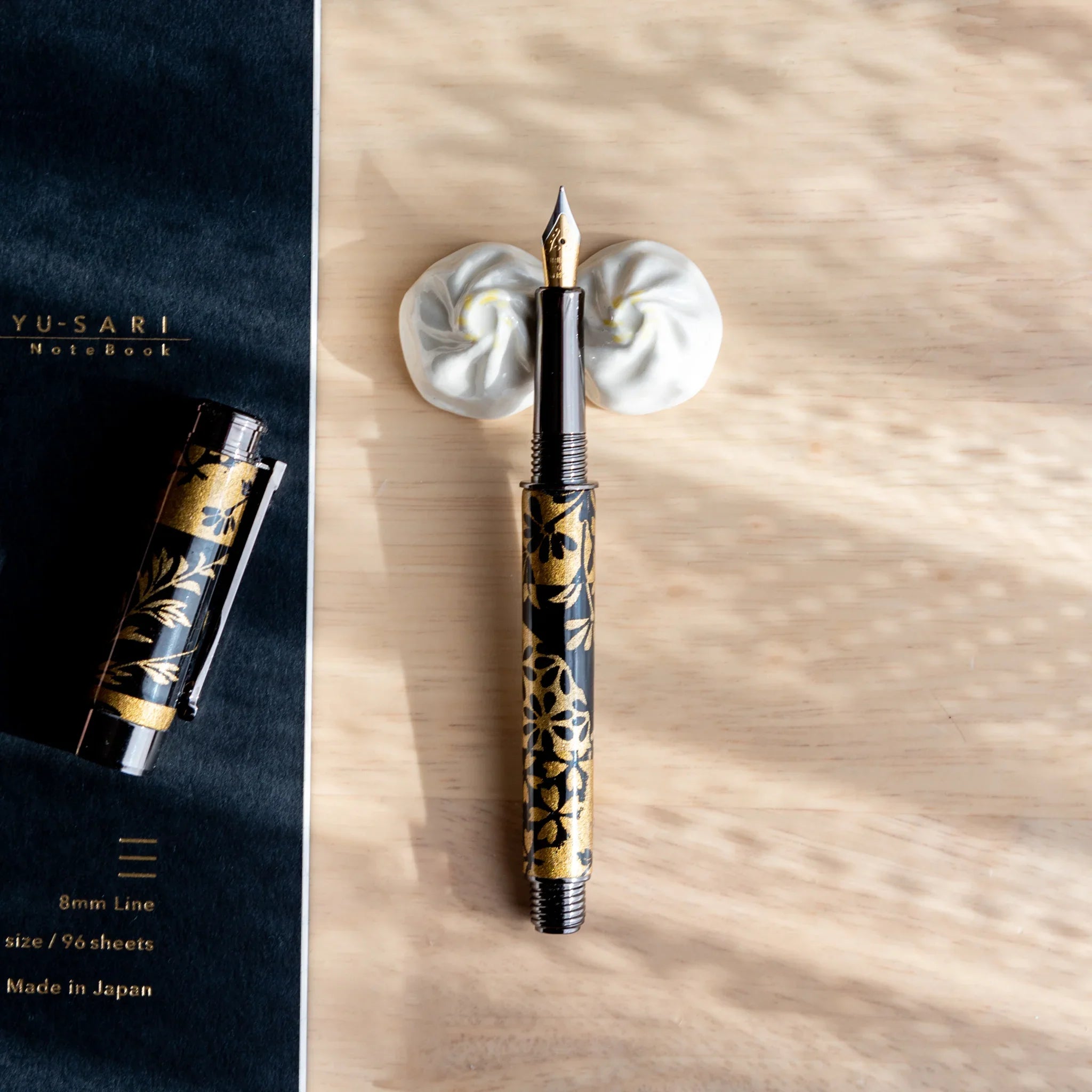 White xiaolongbao ceramic pen rest Japanese handcrafted with visible pleats from angled viewing perspective detail