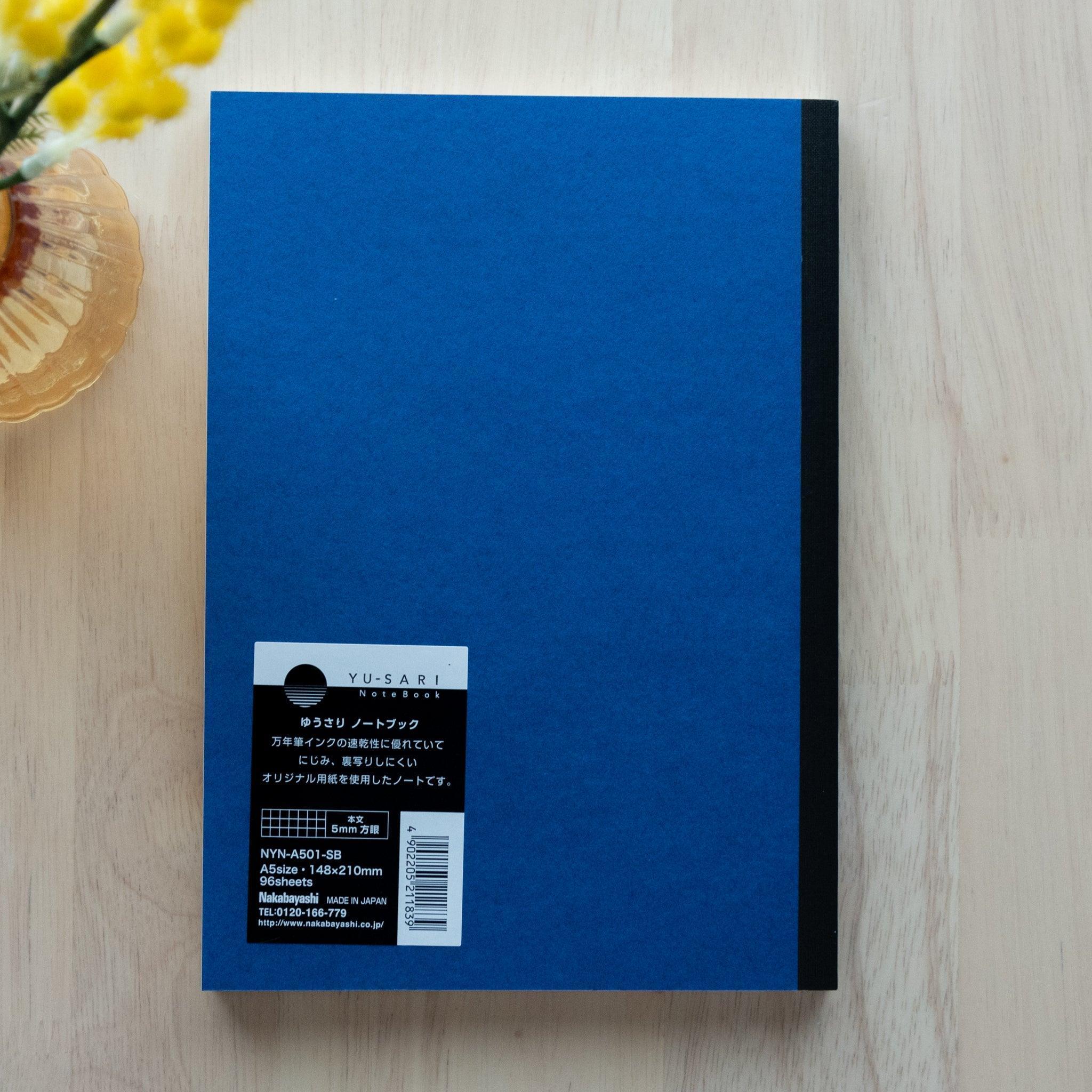 An open "Yu-Sari Notebook" showing blank white pages, ideal for writing or sketching, with smooth and high-quality paper.