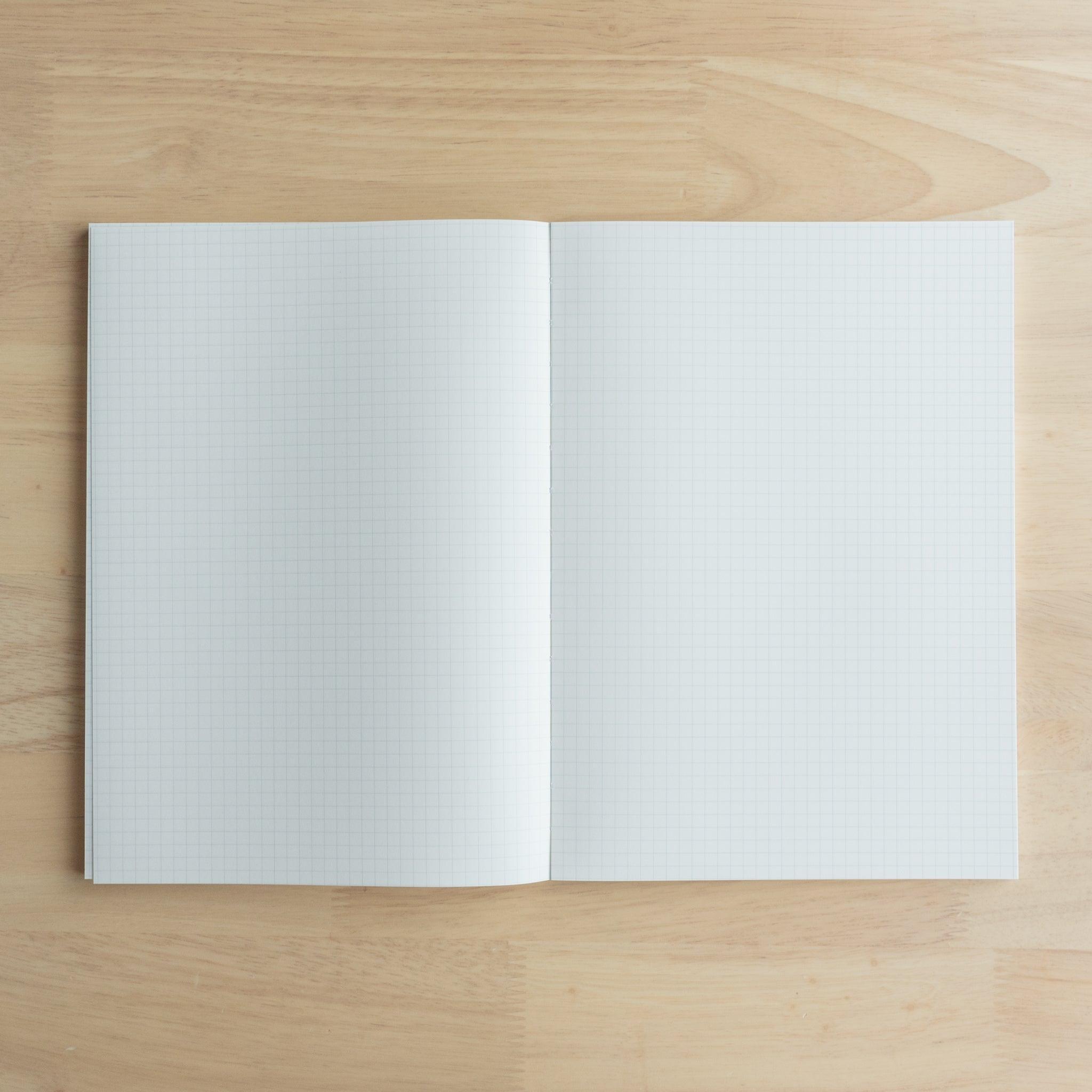 A close-up of the blue "Yu-Sari Notebook" cover, emphasizing the golden logo, grid format, and details: A5, 96 sheets, 5mm grid.