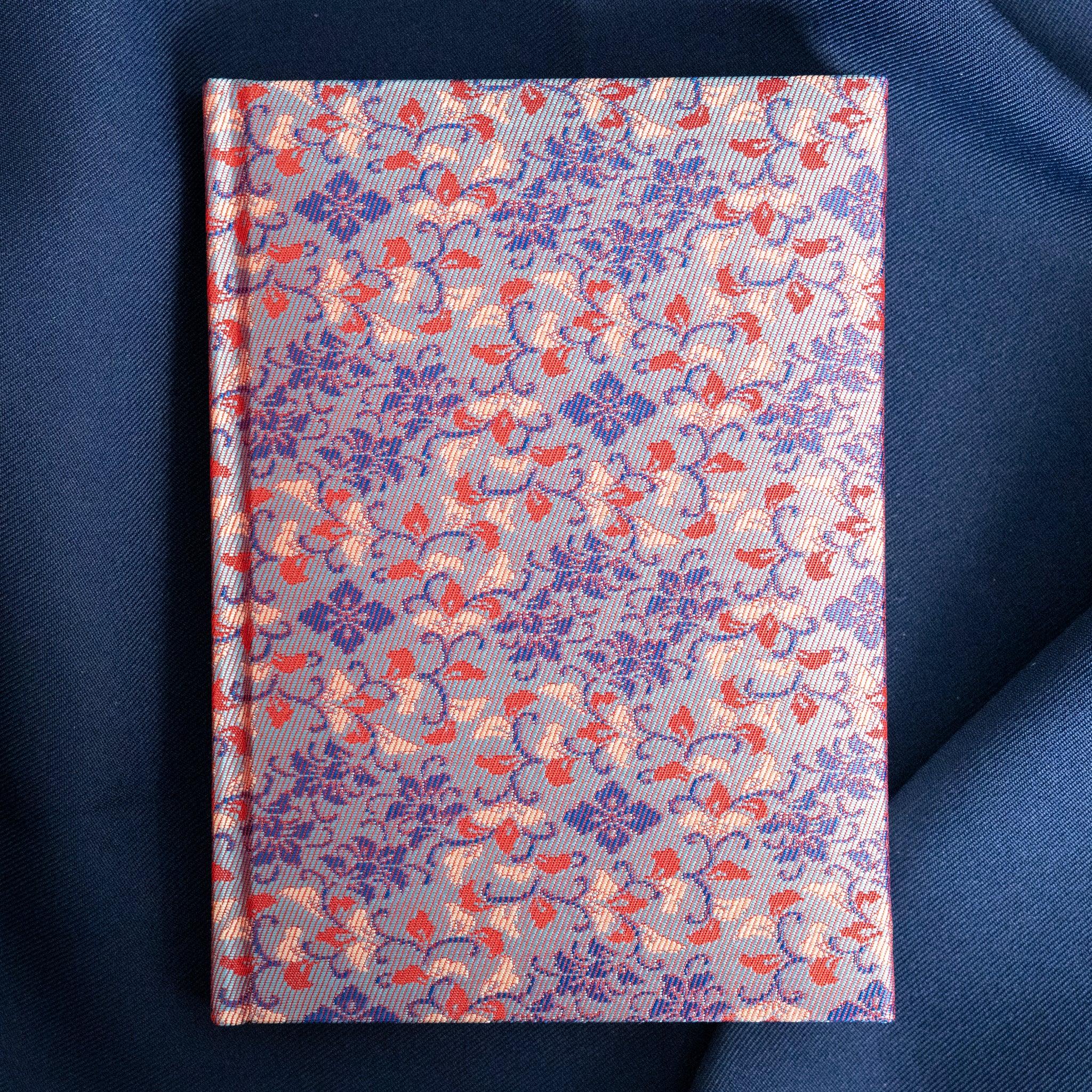 Yusoku Hanabishi Nishijin silk notebook front cover, lavender-pink and red woven floral pattern, no belly band, blue fabric