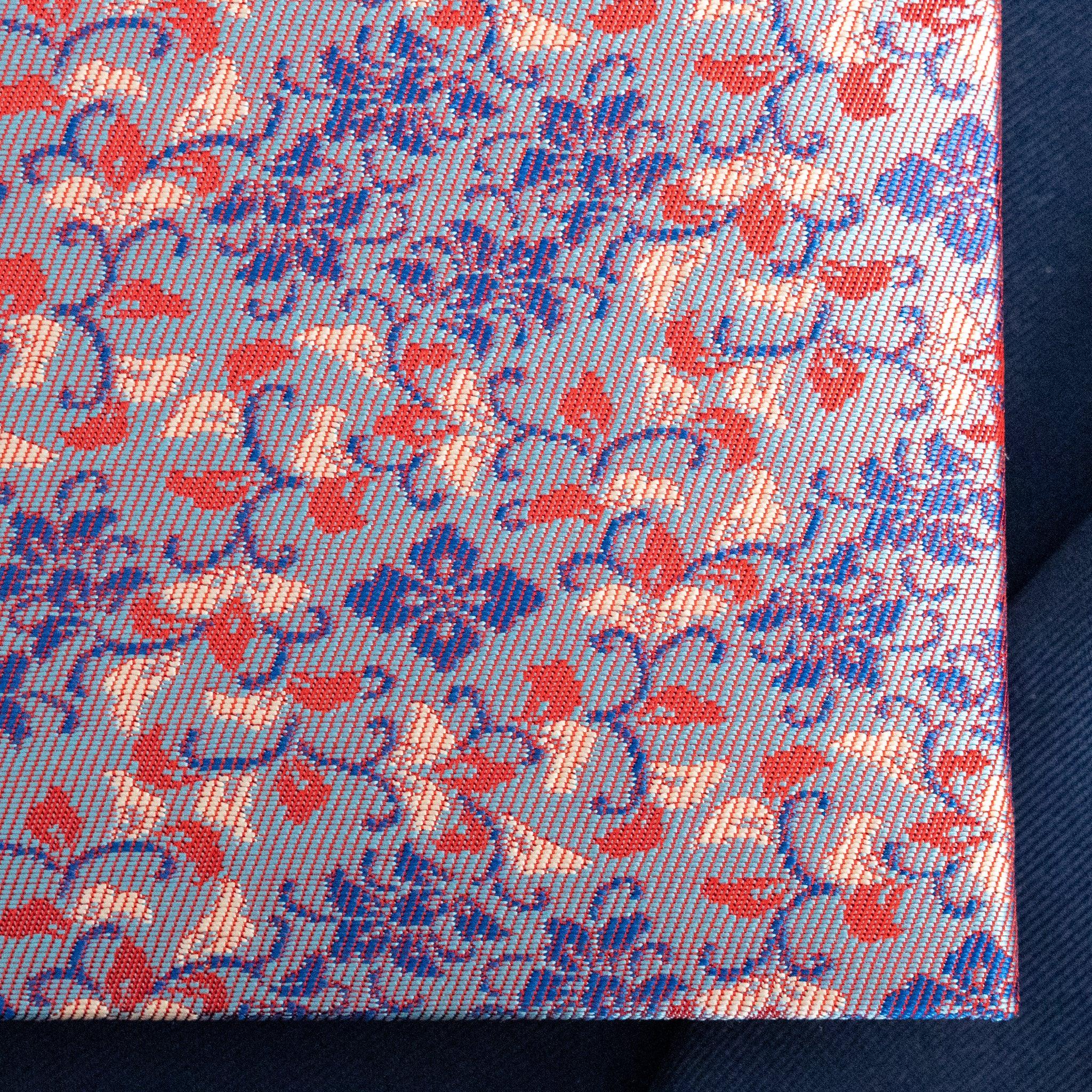 Close-up of Yusoku Hanabishi Nishijin silk weave texture, lavender-pink ground with blue and red woven floral pattern