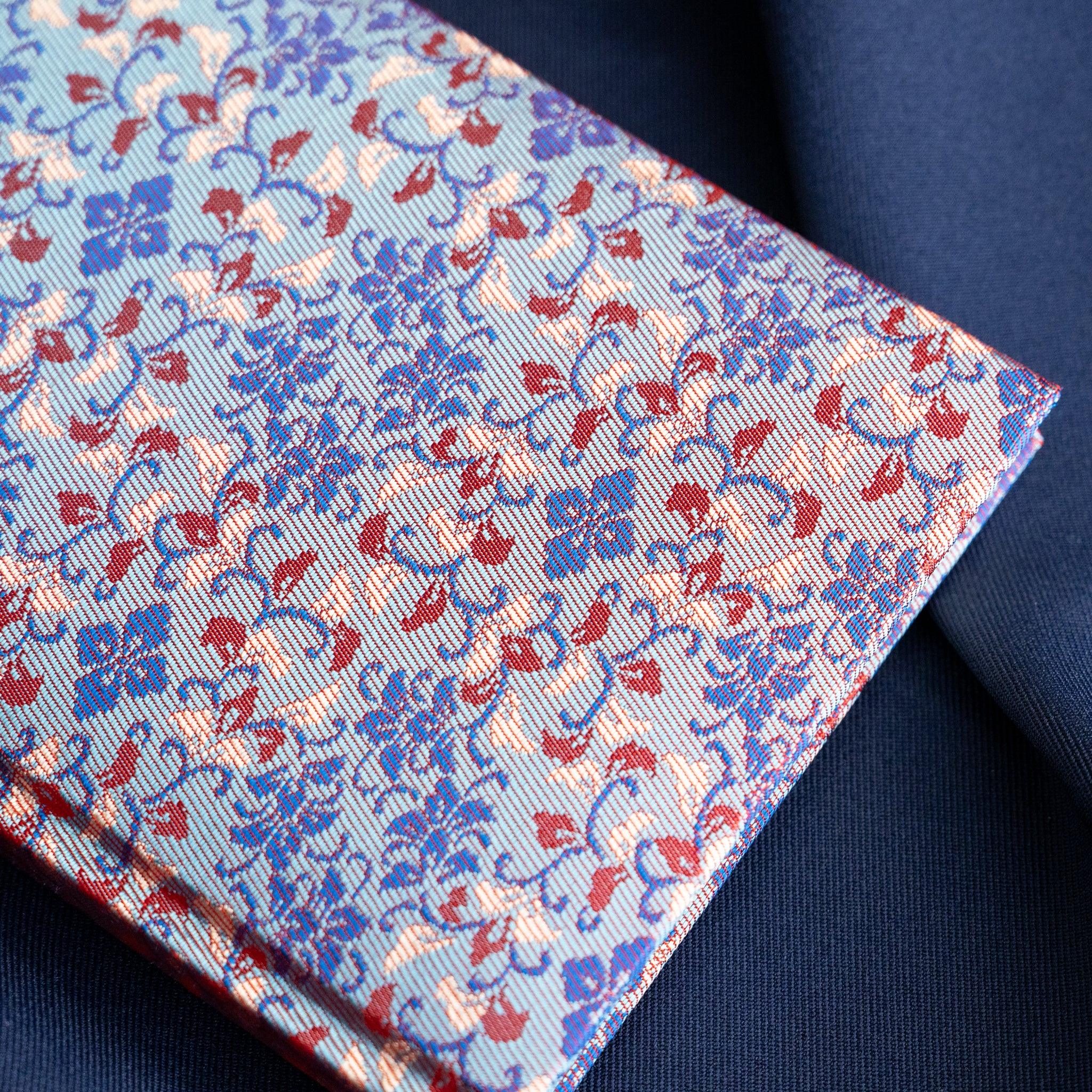 Yusoku Hanabishi Nishijin silk notebook corner view, lavender-pink and red woven floral cover with page edges and binding