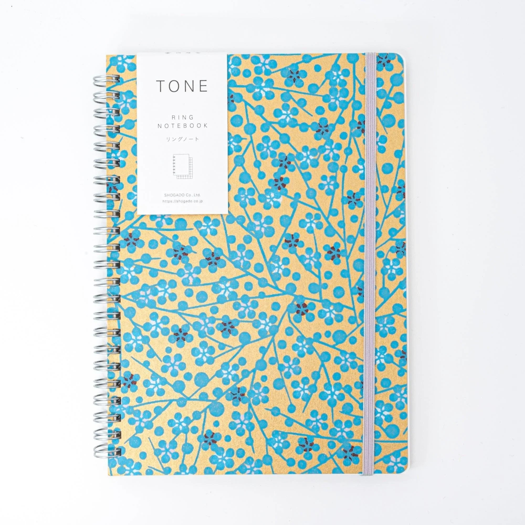 Spiral-bound notebook with blue flower hand-dyed washi cover unfolded showing interior pages for writing