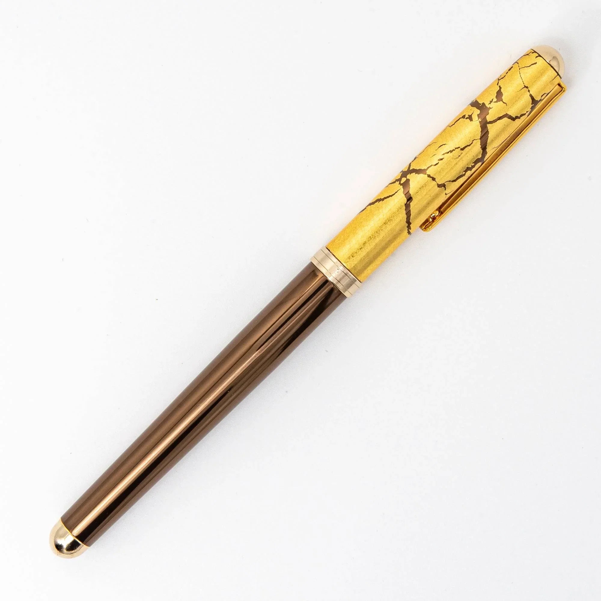 Japanese brown ballpoint pen capped view showing gold crackle cap trim and gold band details diagonal angle