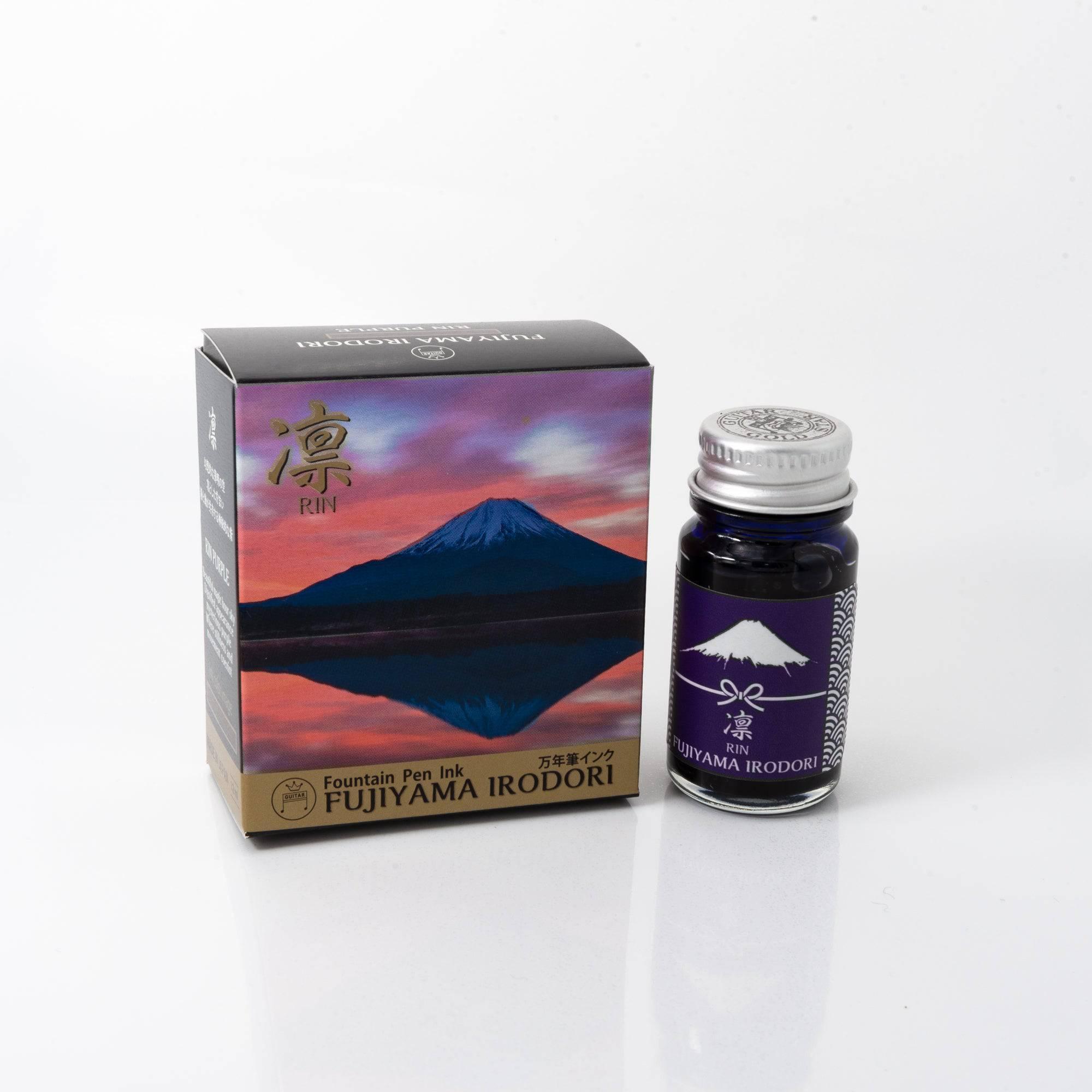 Fujiyama Irodori Rin fountain pen ink bottle with a deep green hue, placed on a wooden desk under soft natural light.