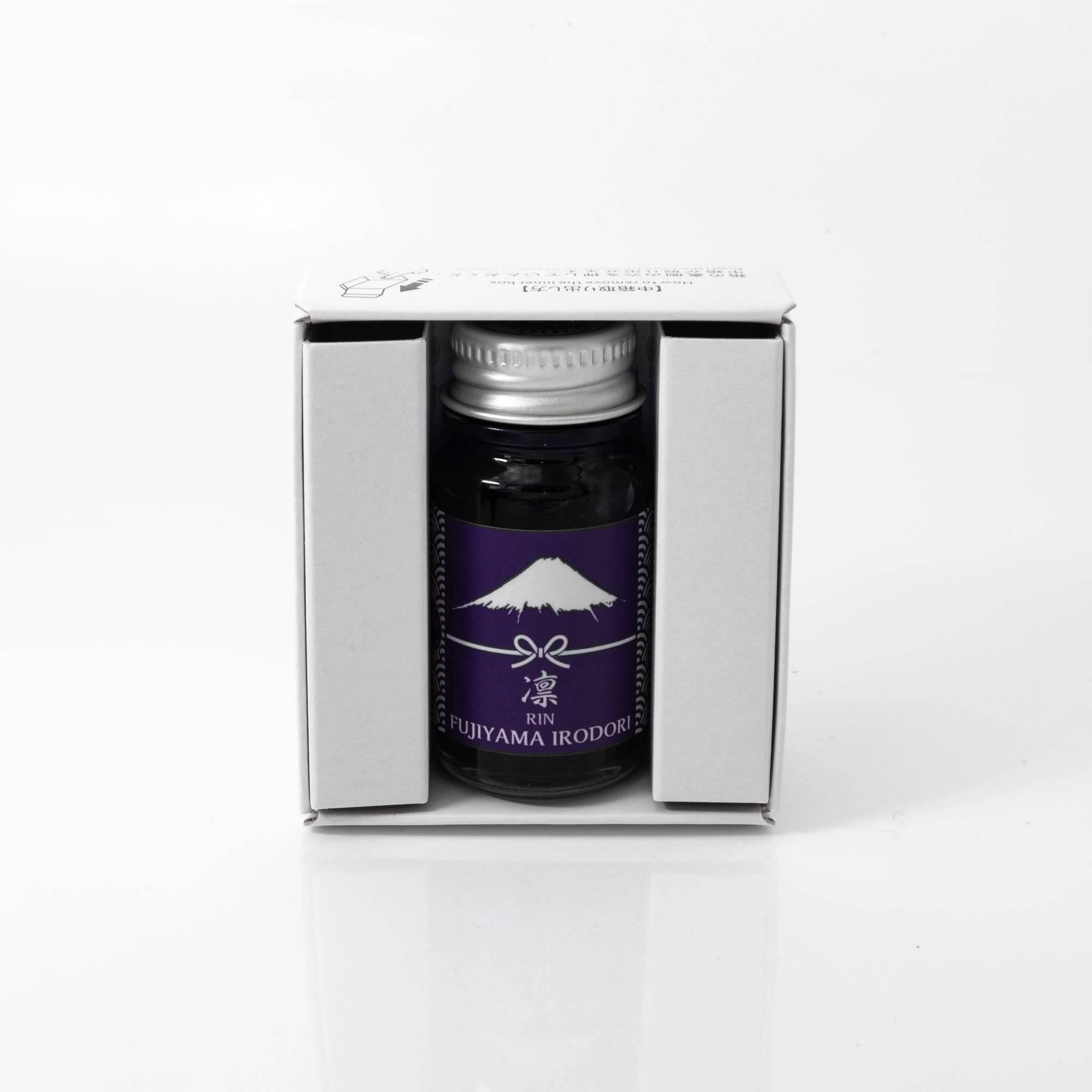 Open Fujiyama Irodori Rin ink bottle with a vivid green liquid, placed beside a fountain pen for a functional and stylish display.