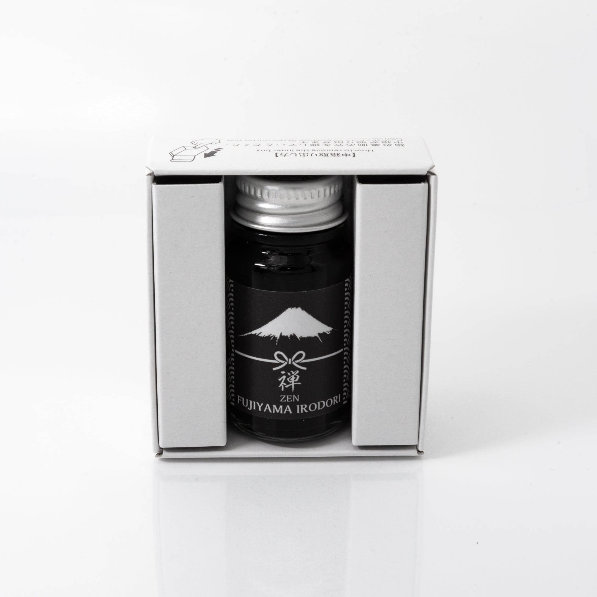 Open Fujiyama Irodori Zen ink bottle with calm gray liquid, placed beside a fountain pen, blending simplicity with elegance.