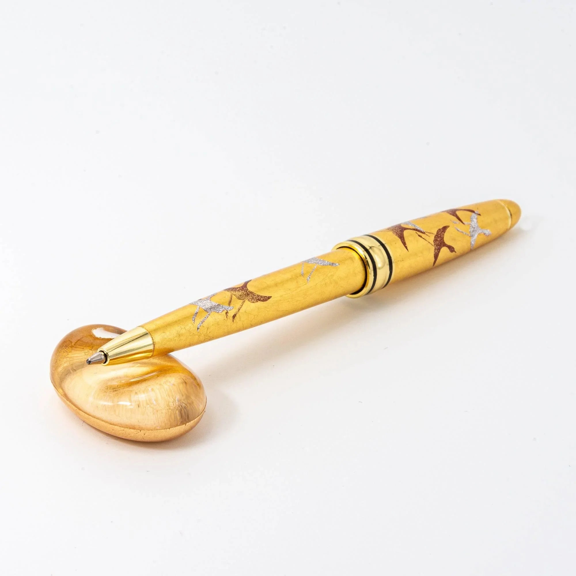 Japanese glass pen rest with amber gold-toned glass featuring organic floating gold leaf inclusions throughout interior