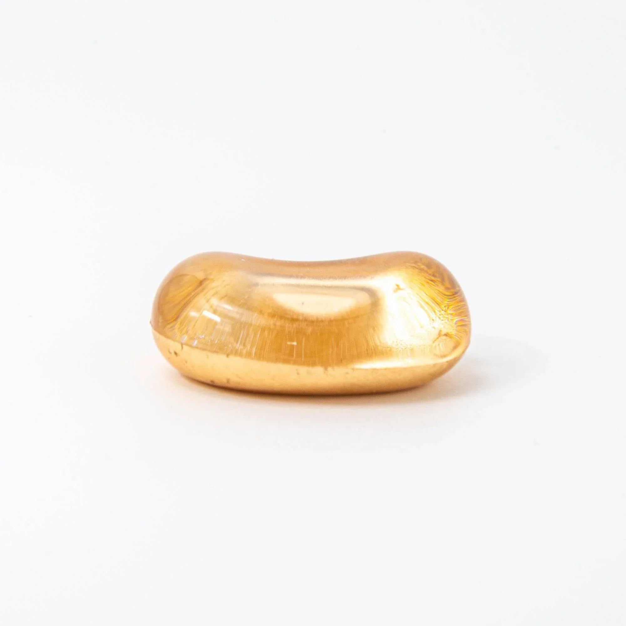 Japanese warm amber glass pen rest featuring scattered flowing gold leaf pattern throughout the translucent interior