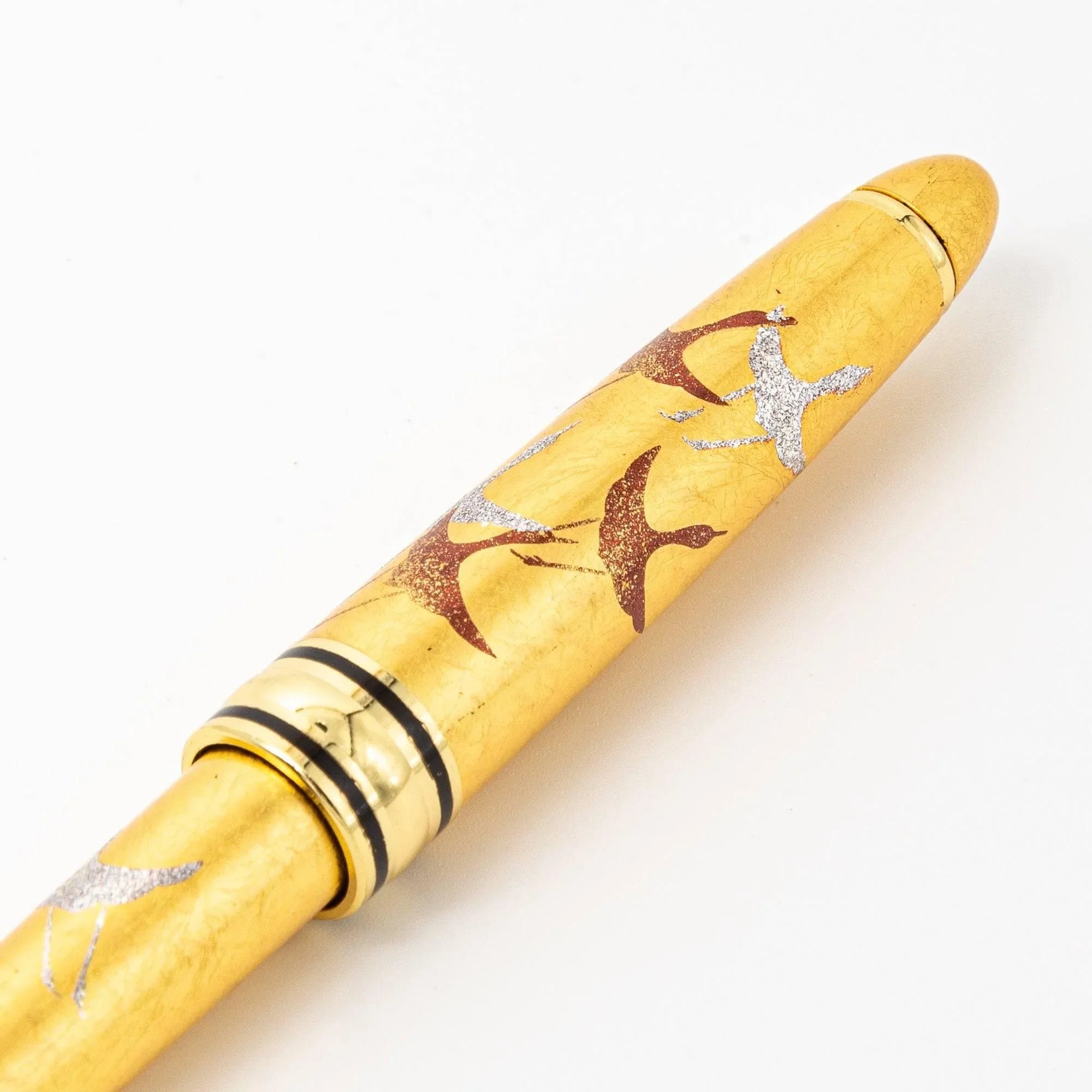 Front view Gold Leaf Crane Makie ballpoint pen with gold finish and traditional crane bird flying design