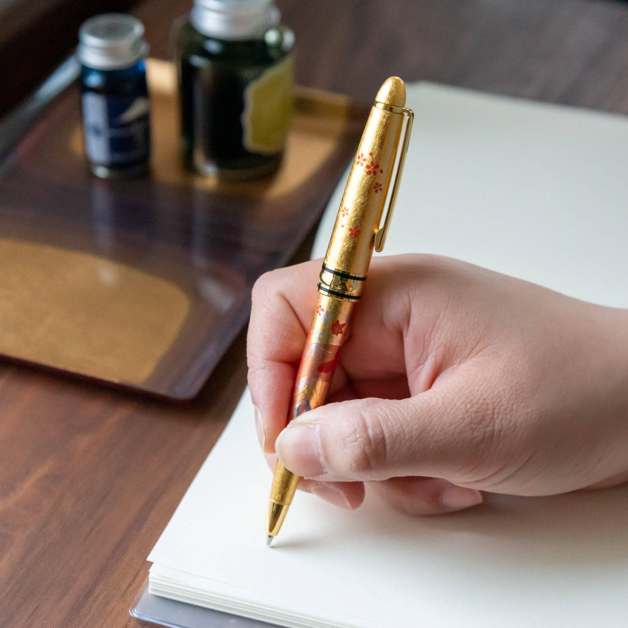 Side-by-side capped and uncapped Gold Leaf Japanese Fan Makie ballpoint pen with gold fan design visible