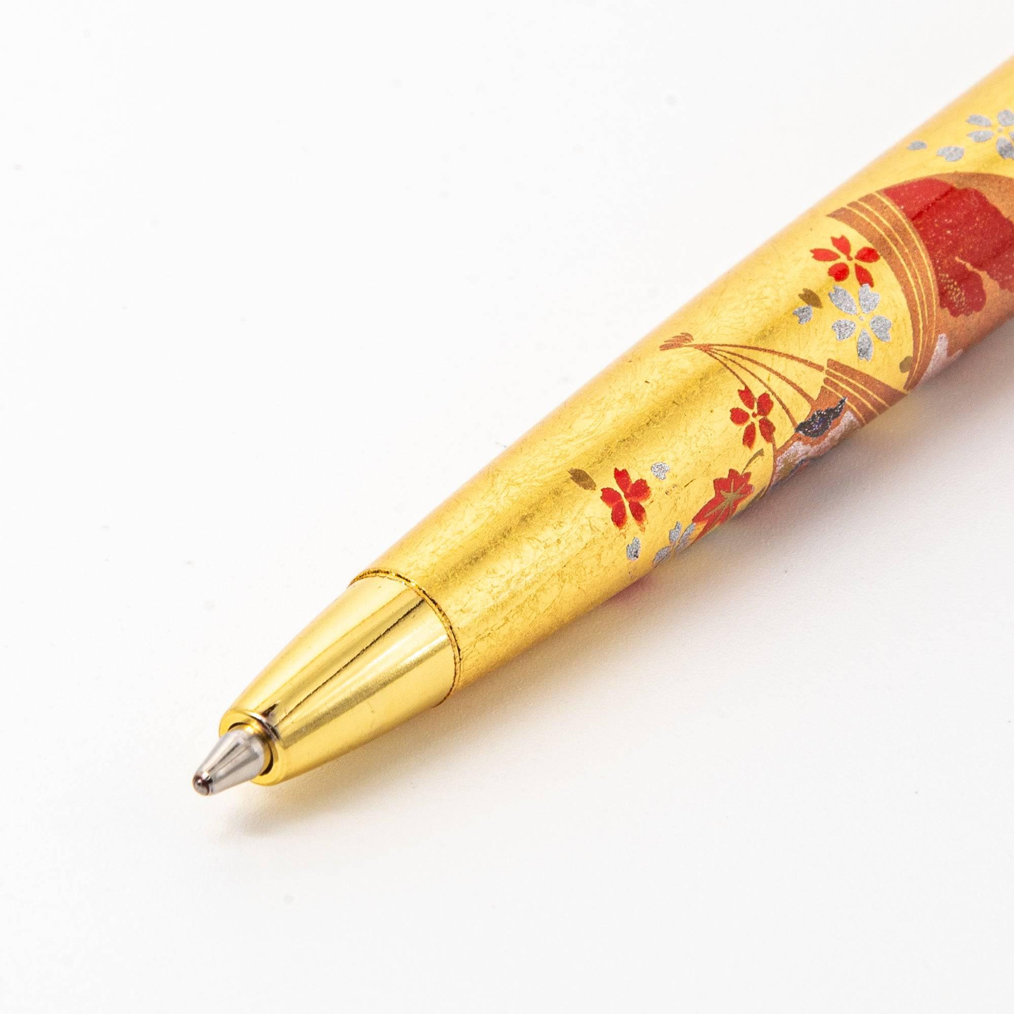 A close-up of the pen's barrel, highlighting the Japanese fan motif and vibrant red accents with cherry blossoms and scenic designs.