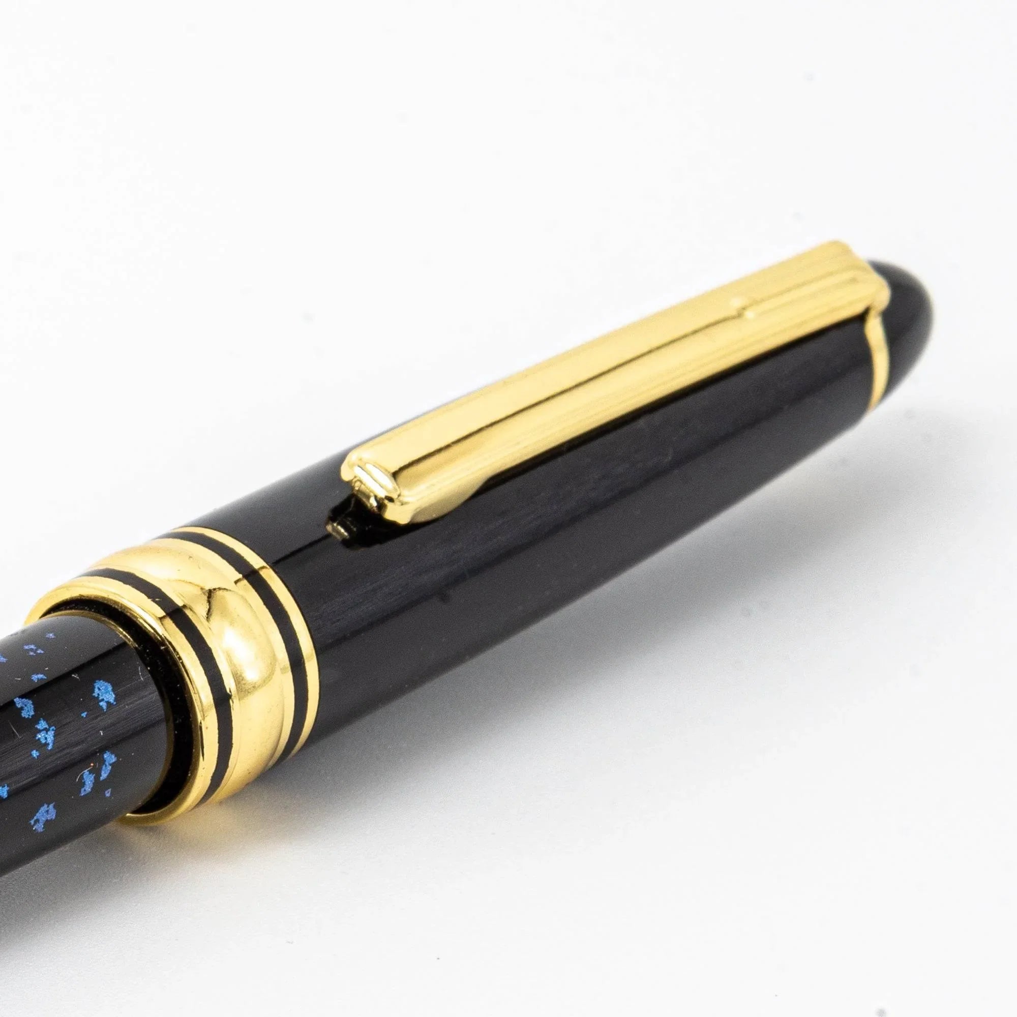 Japanese black ballpoint pen uncapped showing gold clip and trim bands, separate polished gold cap displayed white background