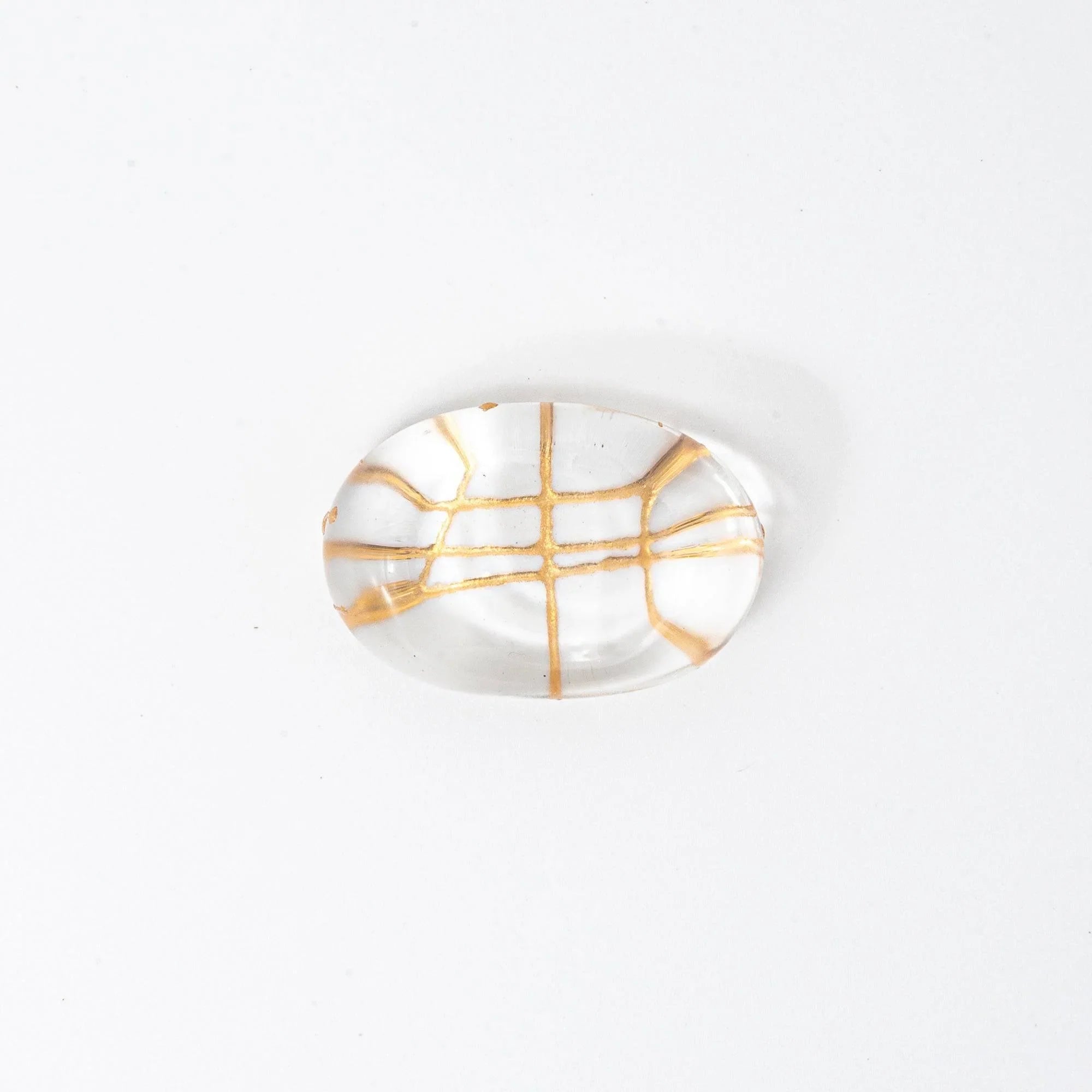 Japanese glass pen rest oval shape clear glass with golden thread crosshatch interior pattern, overhead top-down view