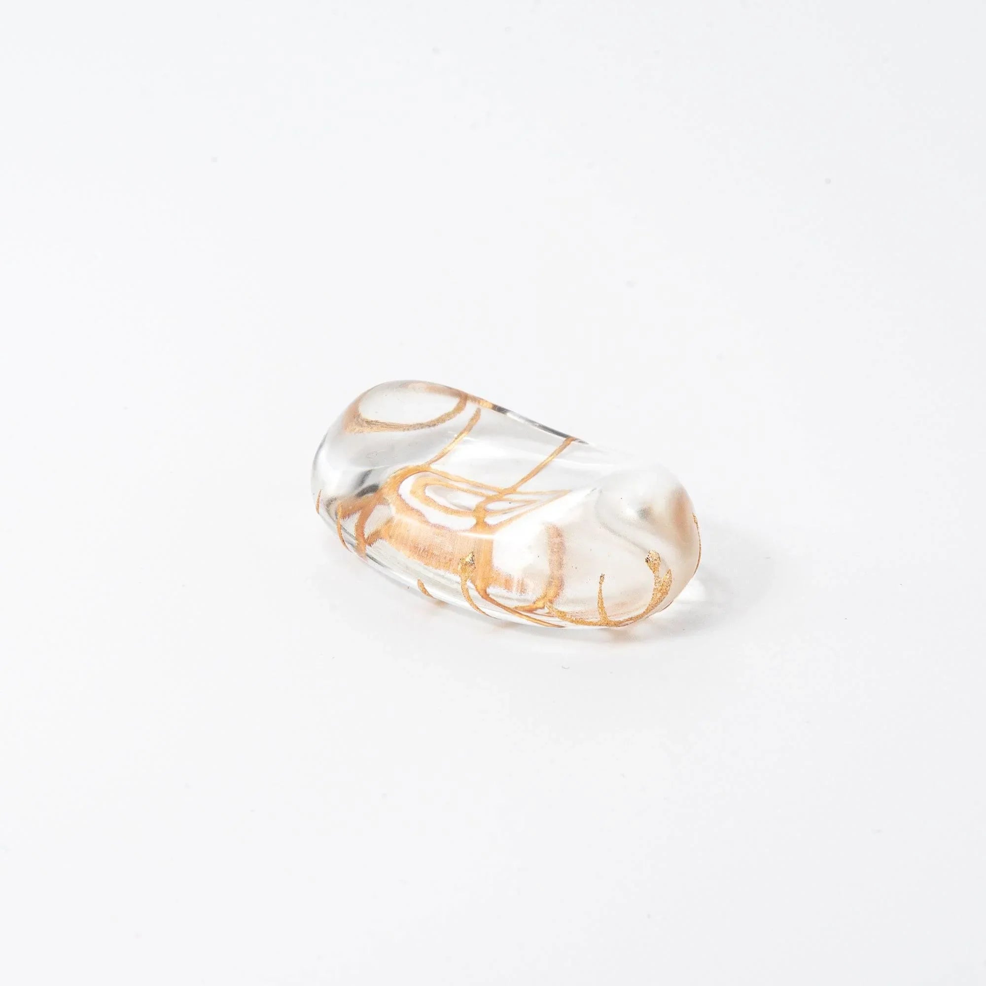 Clear glass pen rest oval shape with golden thread crosshatch interior lattice pattern, three-quarter angled perspective