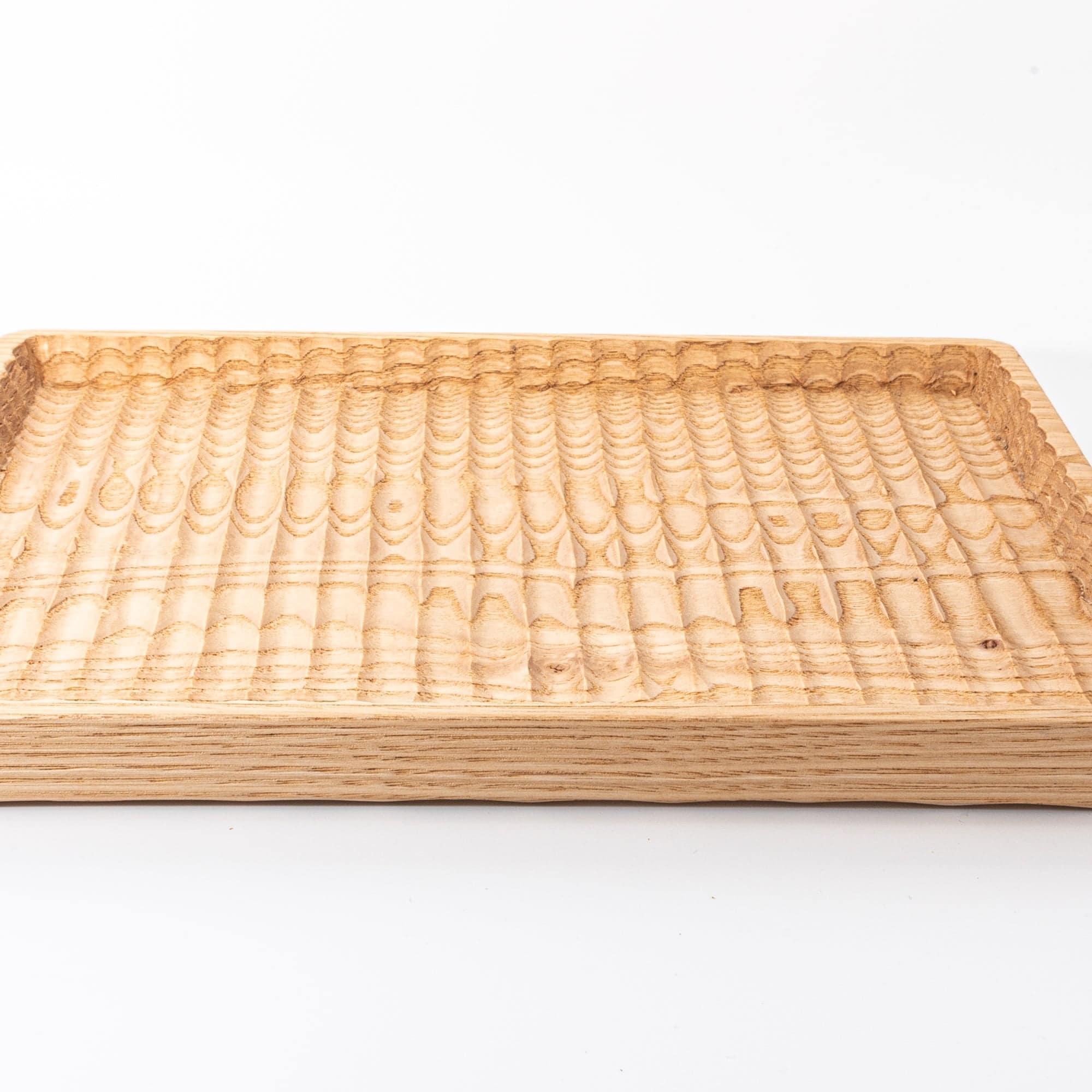 A wooden tray with intricate carved patterns, displayed flat against a white background.