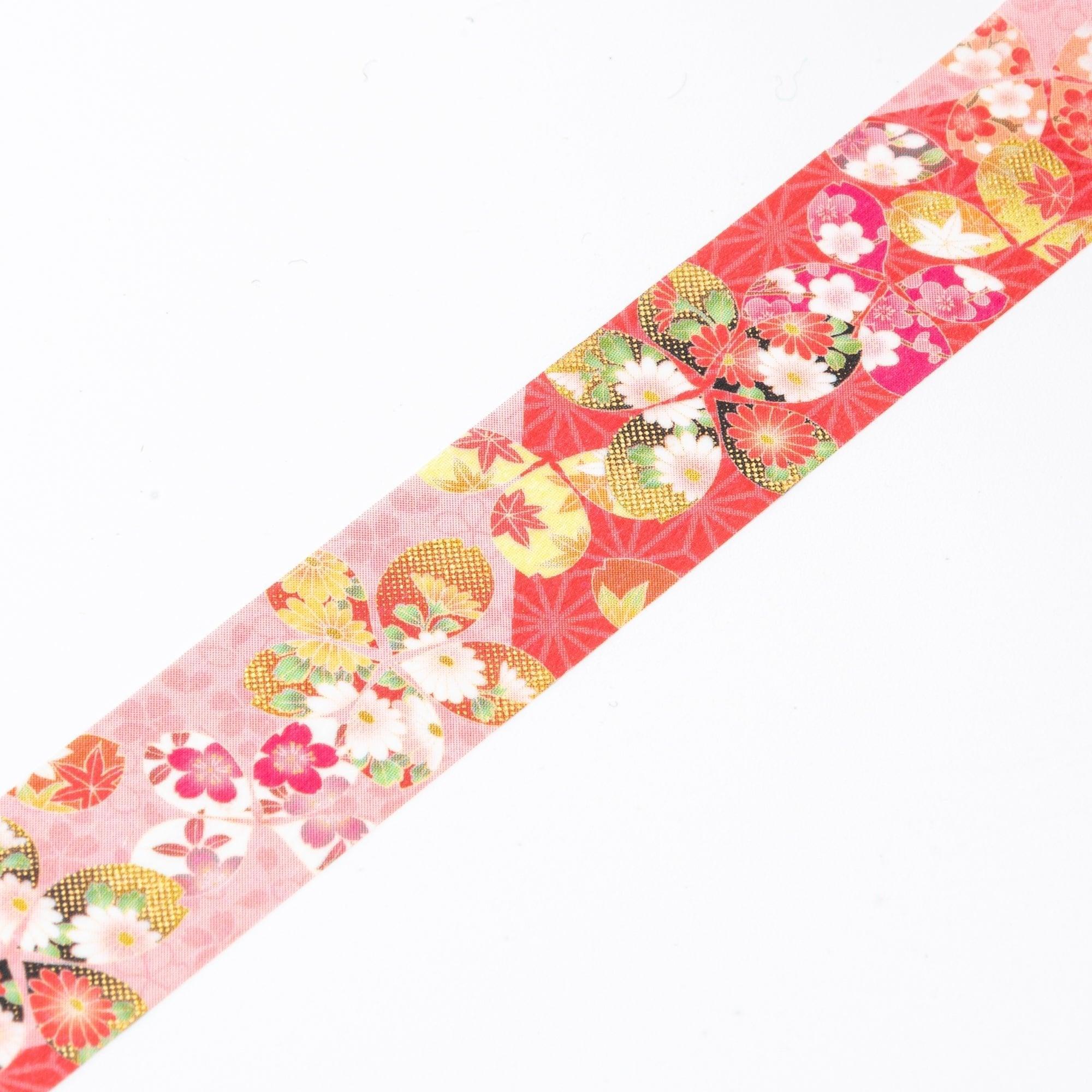 Unrolled Japanese stationery washi tape showcasing delicate sakura motifs, colorful blossoms, and golden accents on a pink and red background.