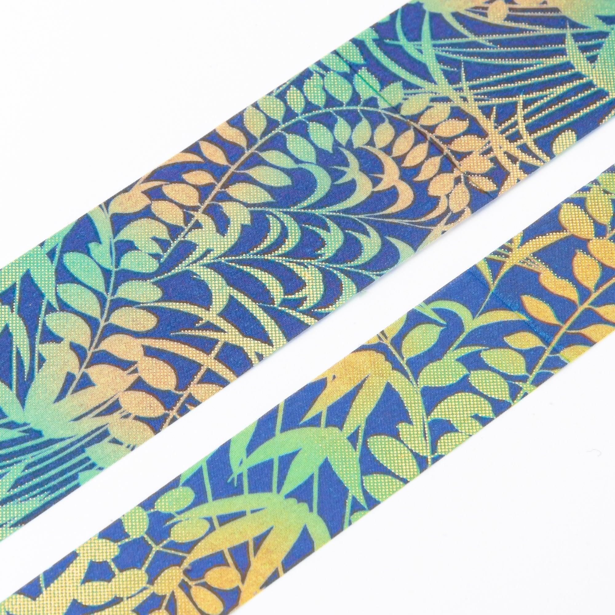 Close-up of Iyo Washi Tape showcasing intricate fresh grass designs, emphasizing vibrant green patterns on a wooden desk.