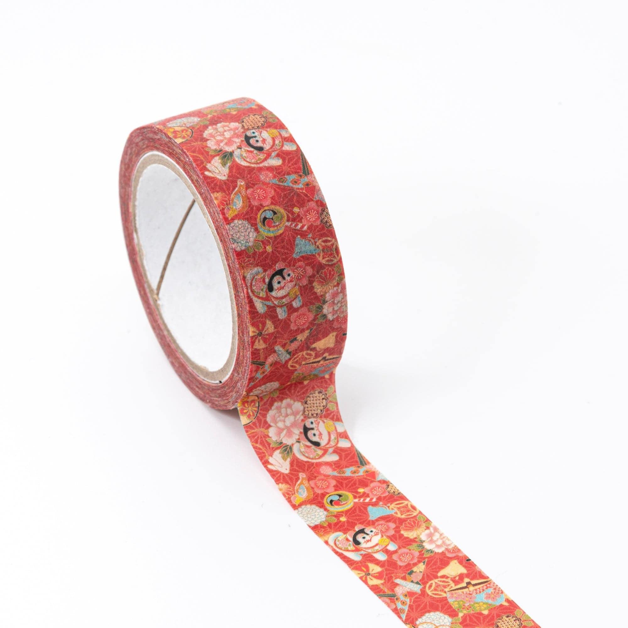 Roll of Iyo Washi Tape with guardian dog designs, unraveling to reveal its detailed motifs, placed on a wooden desk under soft light.
