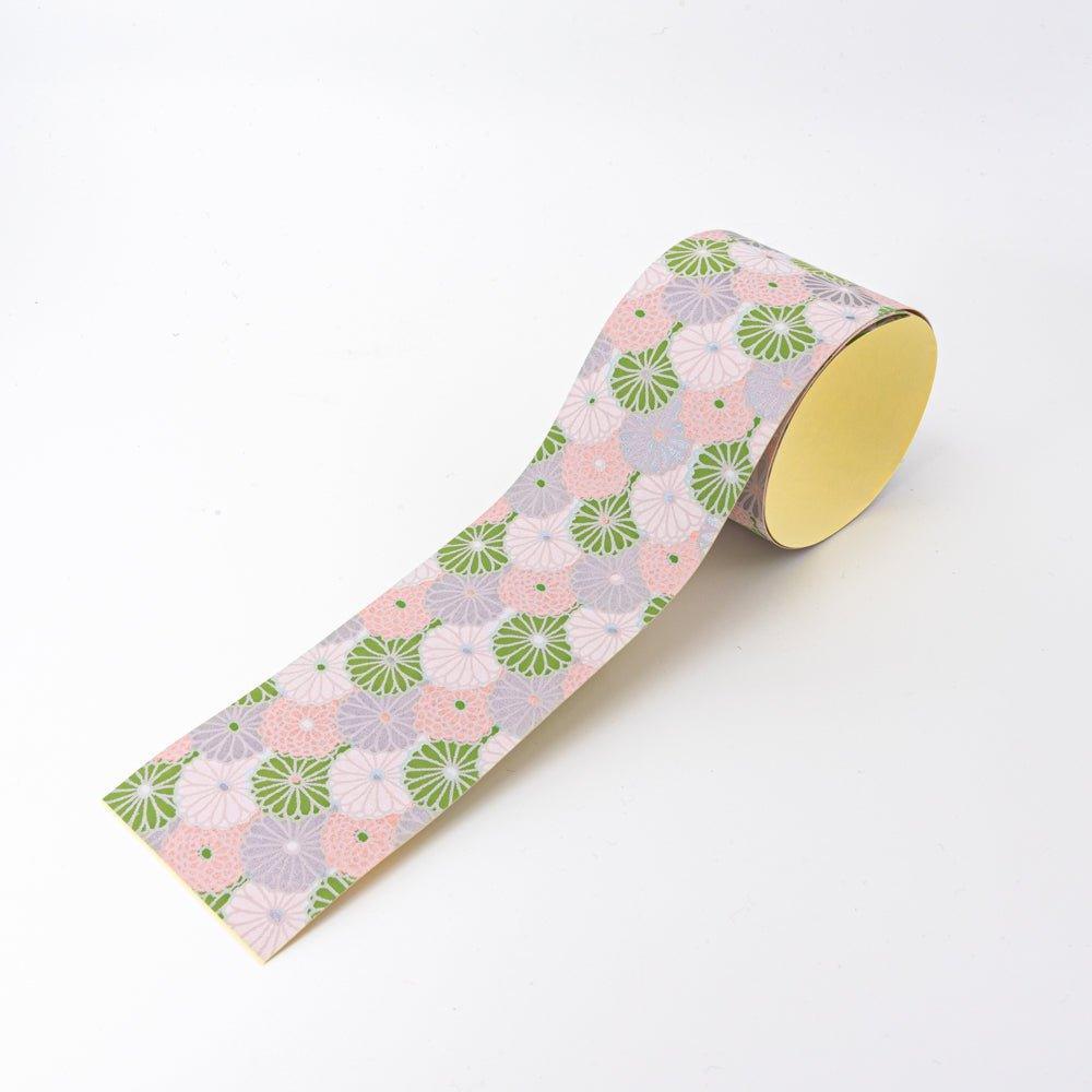 Lavender Mist yuzen washi tape unrolled at angle showing chrysanthemum in green, pink, and lavender, yellow backing visible