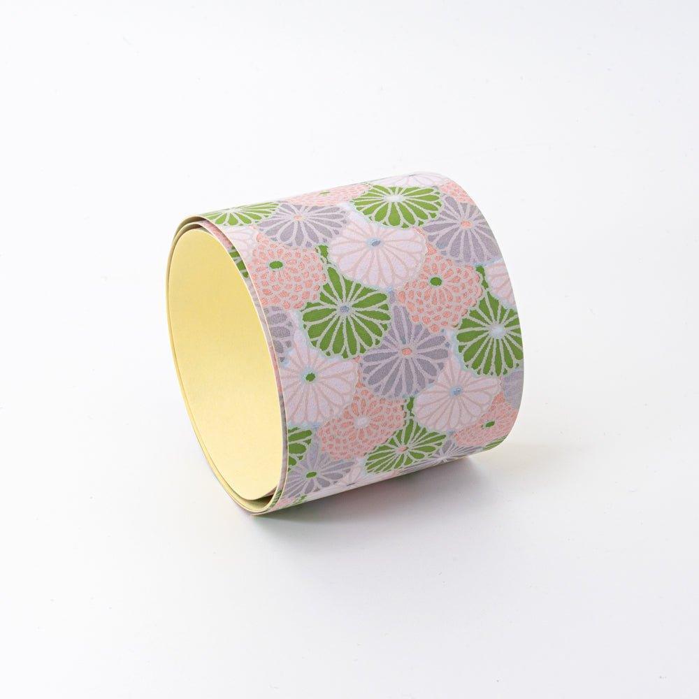 Lavender Mist yuzen washi tape standing upright showing yellow interior and green, pink, lavender chrysanthemum on exterior