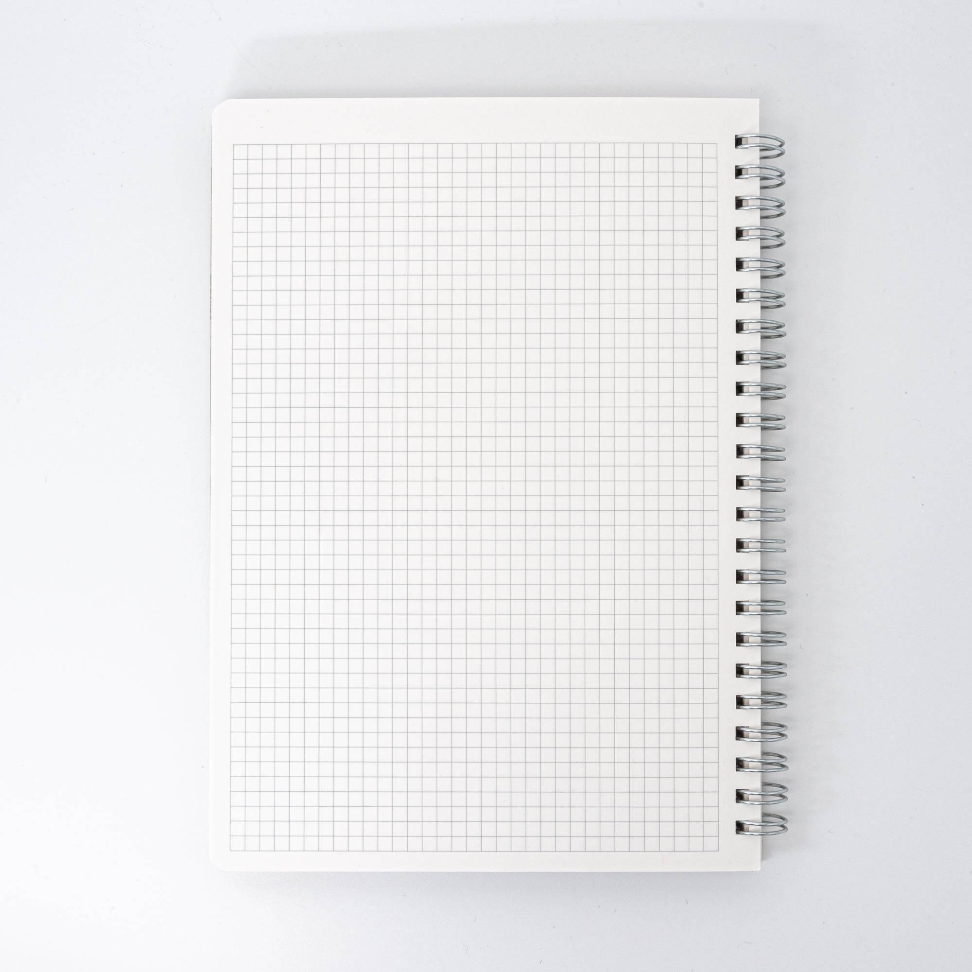 Japanese notebook with spiral binding and grid paper, showcasing a clean and practical layout for writing or drawing.